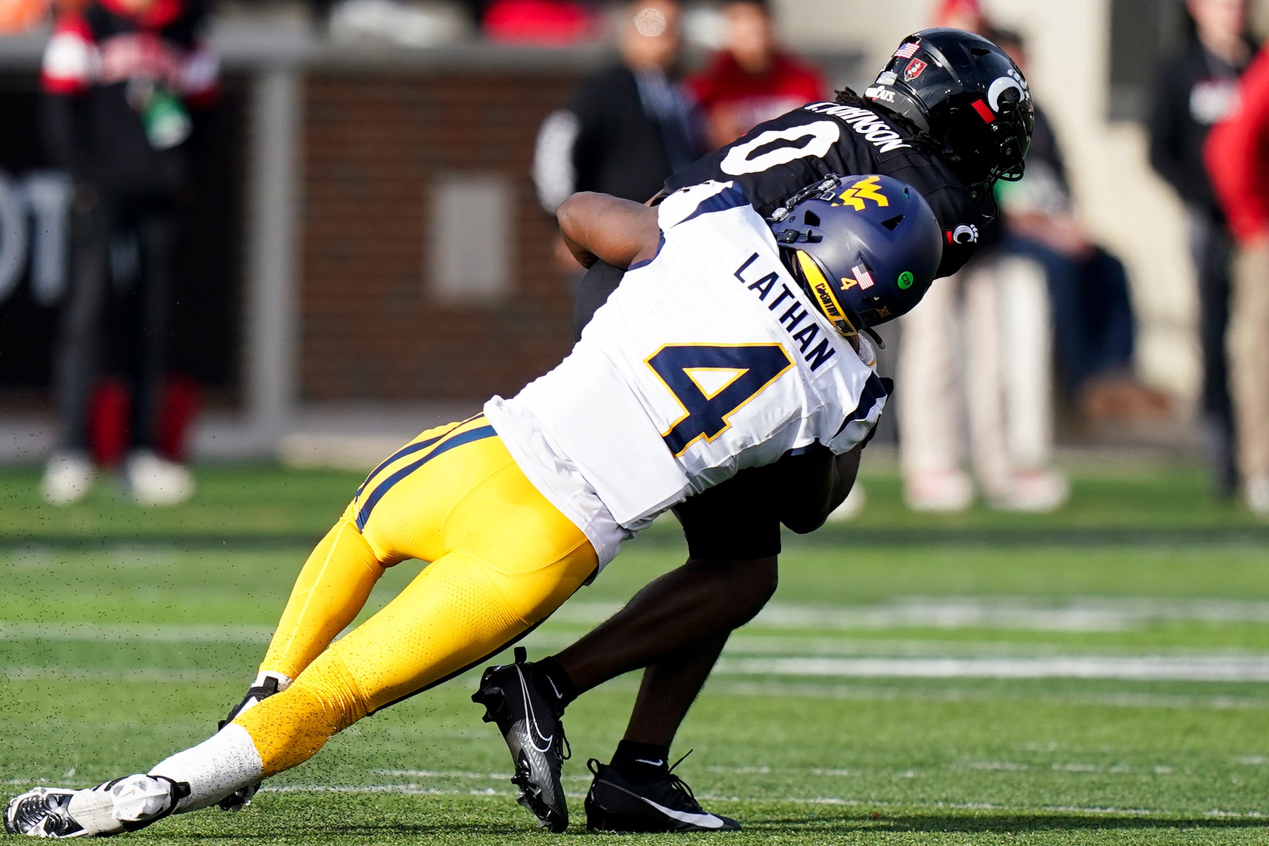West Virginia Mountaineers linebacker Trey Lathan (4) tackles Cincinnati Bearcats wide receiver Tony Johnson (0) in the fourth quarter of a college football game between the Cincinnati Bearcats and West Virginia Mountaineers, Saturday, Nov. 9, 2024, at Nippert Stadium in Cincinnati. Mountaineers won 31-24.