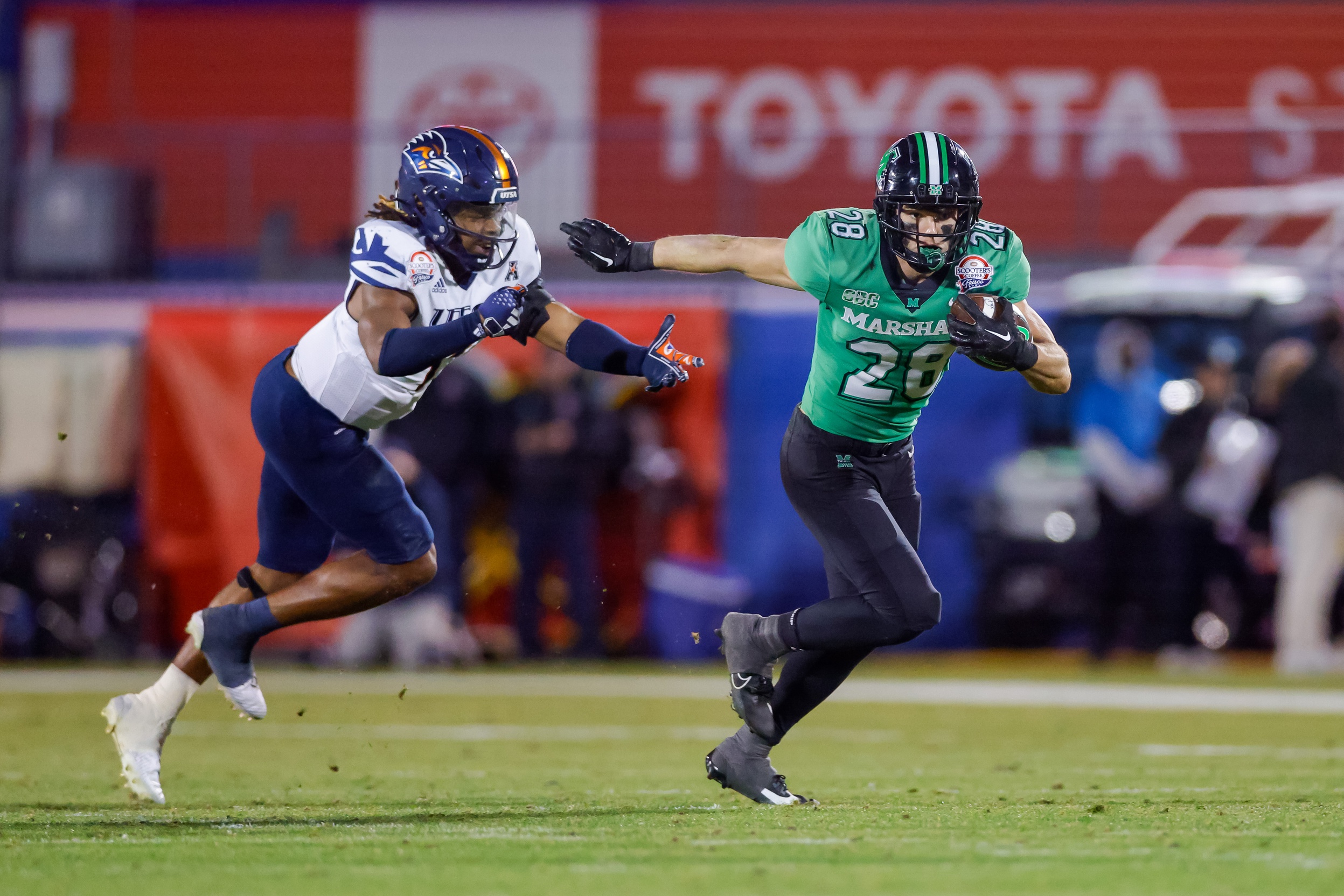 Dec 19, 2023; Frisco, TX, USA; Marshall Thundering Herd running back Ethan Payne (28) runs by UTSA Roadrunners linebacker Trey Moore (1) during the third quarter at Toyota Stadium.