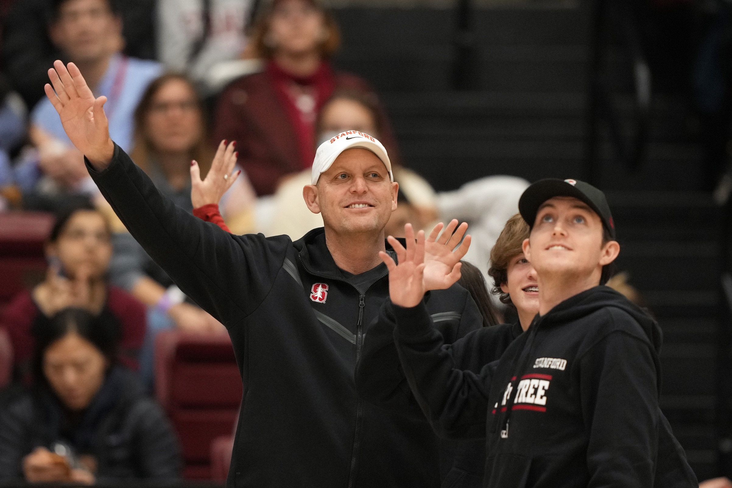 Dec 18, 2022; Stanford, California, USA; Stanford Cardinal football head coach Troy Taylor, center, waves while standing on the court with family during the second quarter of the game between the Stanford Cardinal and the Tennessee Lady Vols at Maples Pavilion.