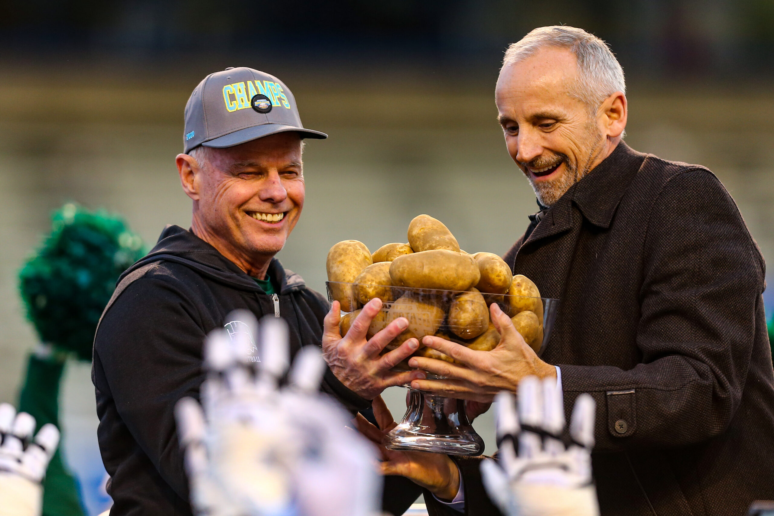 Jan 3, 2020; Boise, Idaho, USA; Ohio Bobcats head coach Frank Solich (left) receives the Famous Idaho Potato Bowl trophy from bowl executive director Kevin McDonald after defeating the Nevada Wolf Pack at Albertsons Stadium. Ohio won 30-21.