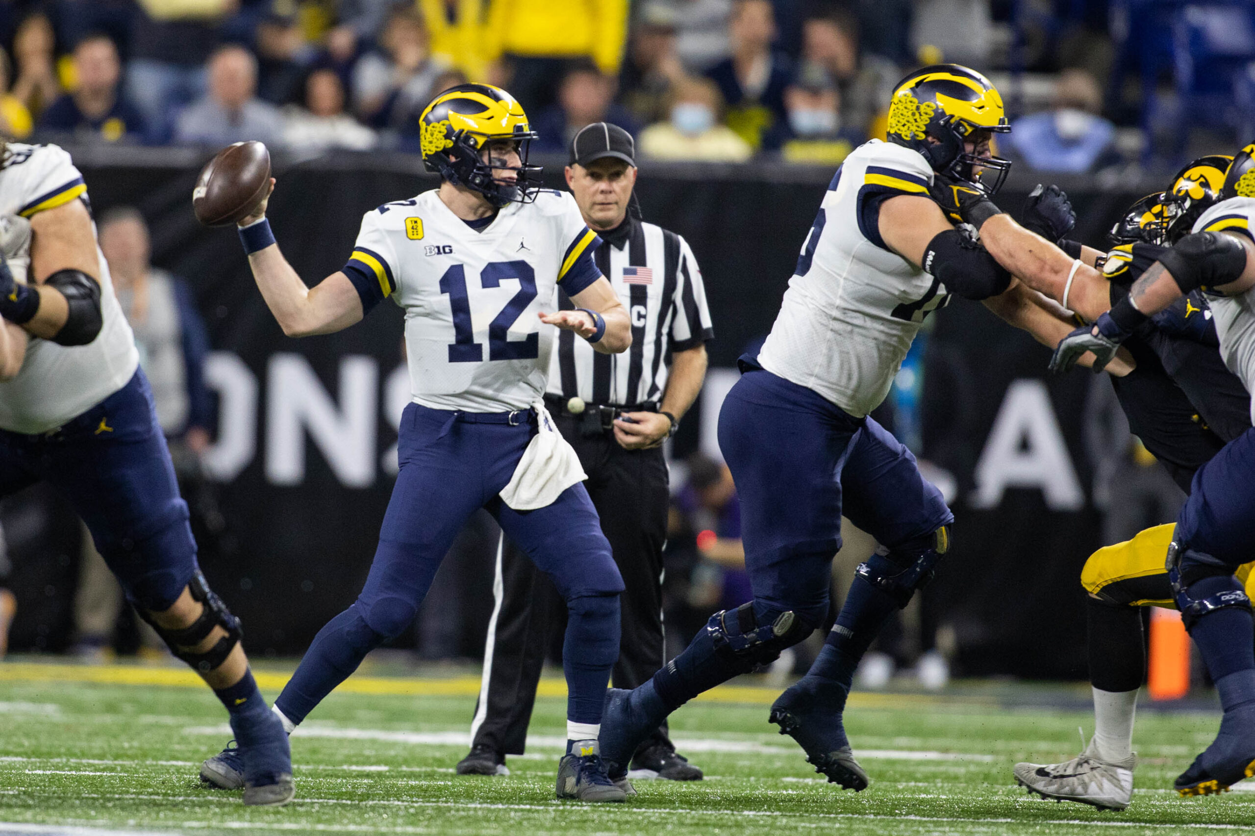 Dec 4, 2021; Indianapolis, IN, USA; Michigan Wolverines quarterback Cade McNamara (12) passes the ball in the second quarter against the Iowa Hawkeyes at Lucas Oil Stadium.