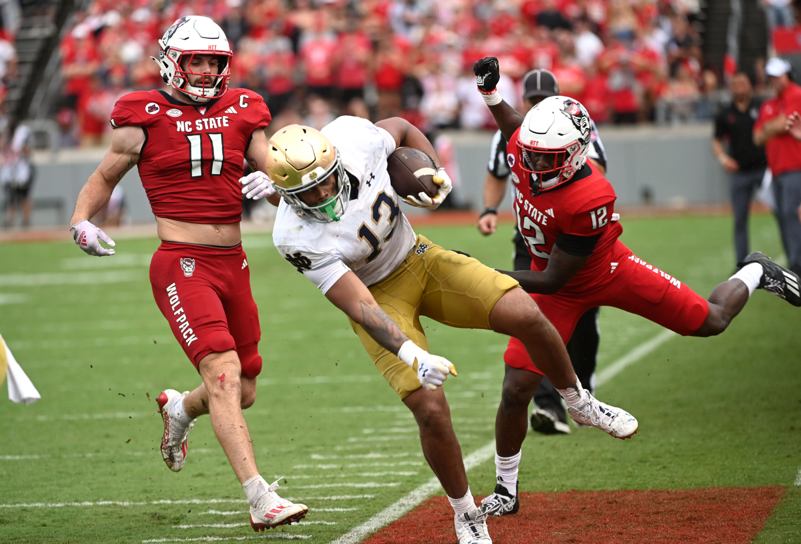 Sep 9, 2023; Raleigh, North Carolina, USA; Notre Dame Fighting Irish tight end Holden Staes (13) is knocked out of bounds by North Carolina State Wolfpack safety Devan Boykin (12) after a catch during the second half at Carter-Finley Stadium.