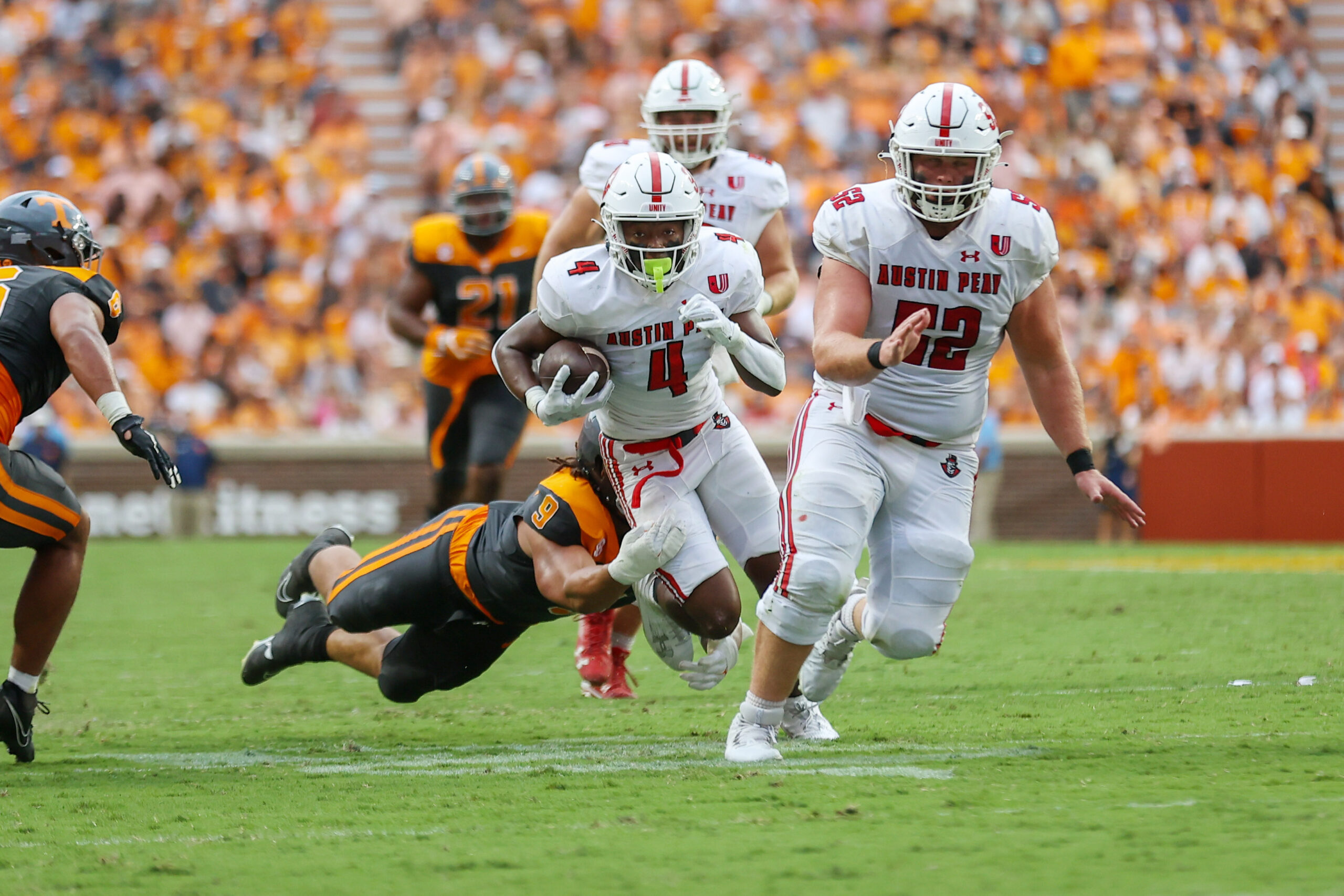 Sep 9, 2023; Knoxville, Tennessee, USA; Austin Peay Governors wide receiver Tre Shackelford (4) runs the ball against Tennessee Volunteers defensive lineman Tyler Baron (9) during the first half at Neyland Stadium.