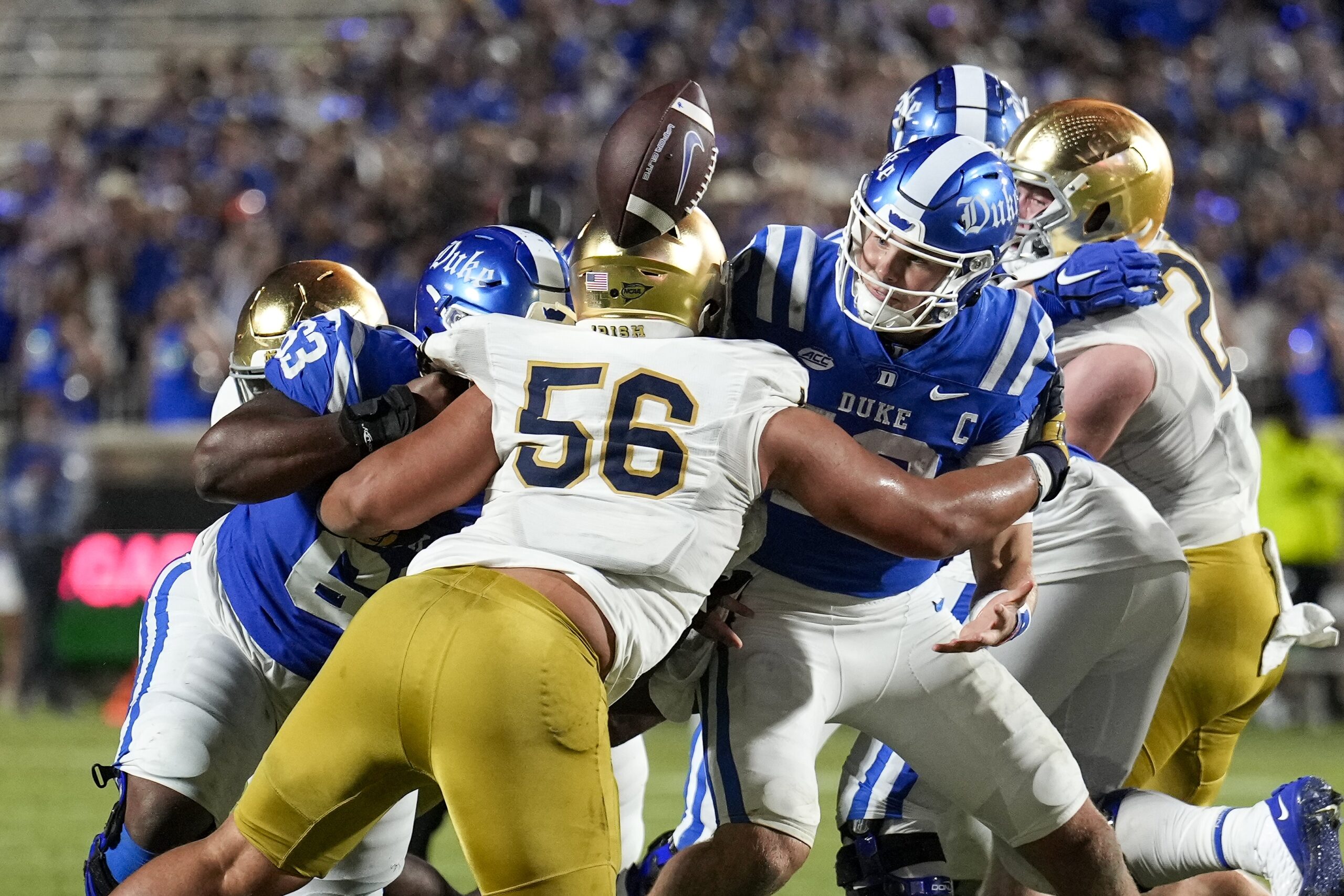 Duke Blue Devils quarterback Riley Leonard (13) loses the football near the goal line hit by Notre Dame Fighting Irish defensive lineman Howard Cross III (56). 