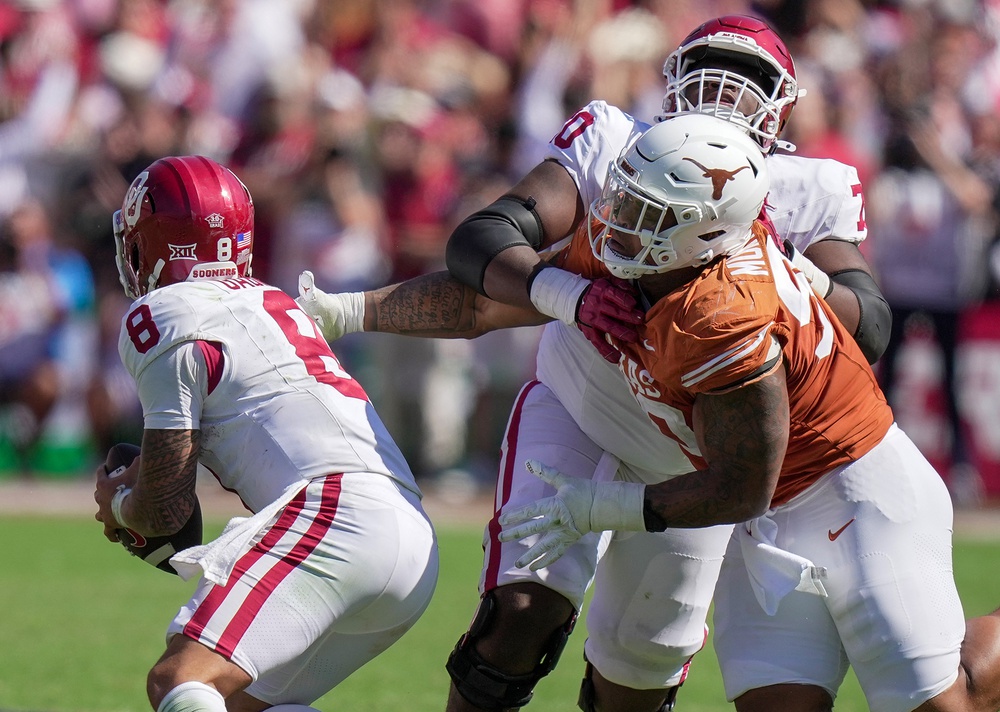 Oct 7, 2023; Dallas, Texas, USA; Oklahoma Sooners offensive lineman Cayden Green (70) blocks Texas Longhorns defensive lineman Byron Murphy II (90) as Oklahoma quarterback Dillon Gabriel (8) runs the ball in the fourth quarter at the Cotton Bowl. This game makes up the 119th rivalry match up.