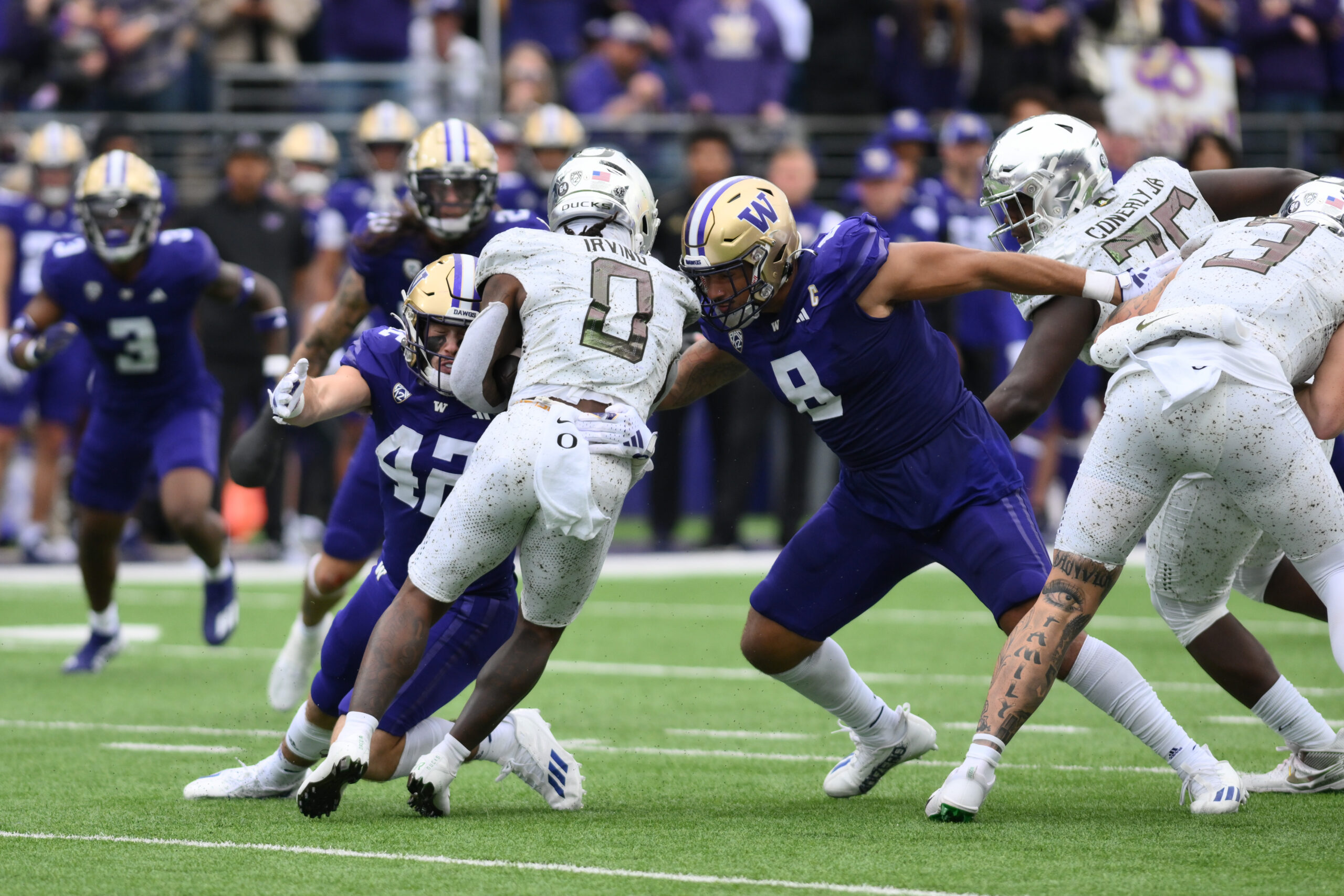 Oct 14, 2023; Seattle, Washington, USA; Washington Huskies defensive end Bralen Trice (8) tackles Oregon Ducks running back Bucky Irving (0) during the second half at Alaska Airlines Field at Husky Stadium.