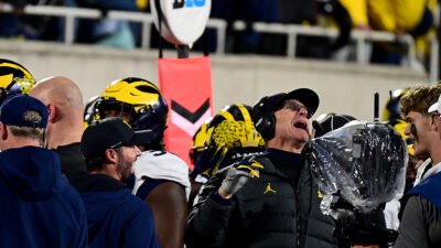 Wolverines head coach Jim Harbaugh shouts and grins after a turnover late in the game took the ball away from the Michigan State Spartans at Spartan Stadium.