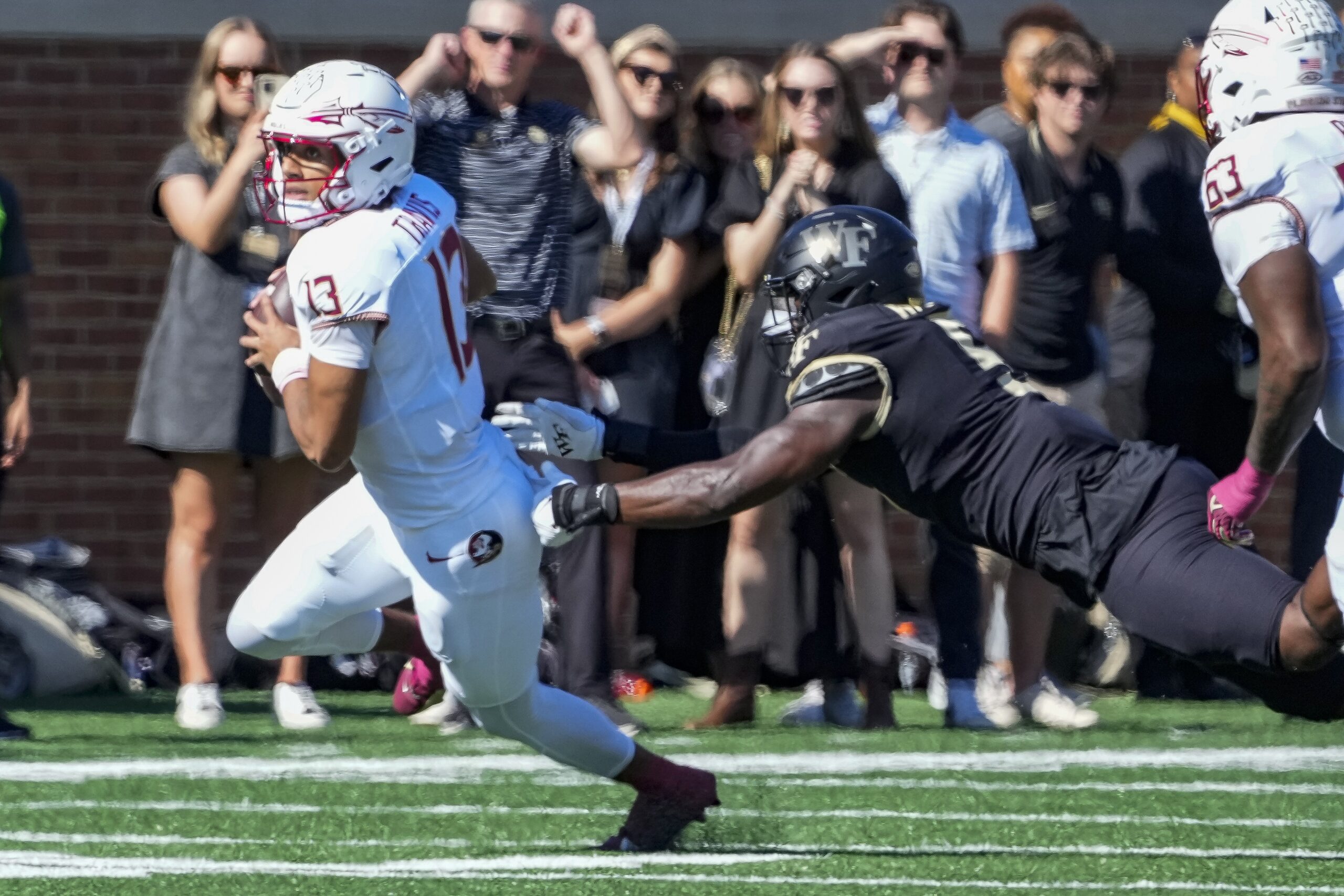 Florida State Seminoles quarterback Jordan Travis (13) is chased out of the pocket.