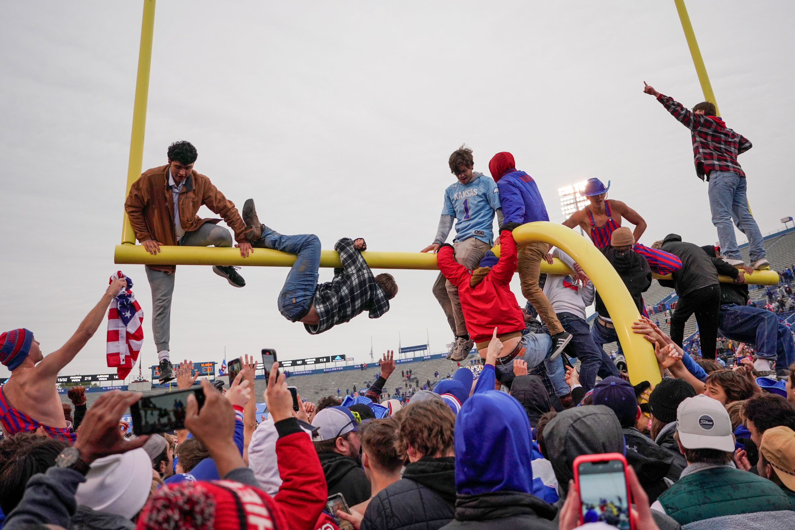 Oct 28, 2023; Lawrence, Kansas, USA; Several students climb on and tear down the goalpost after Kansas Jayhawks defeat the Oklahoma Sooners at David Booth Kansas Memorial Stadium.