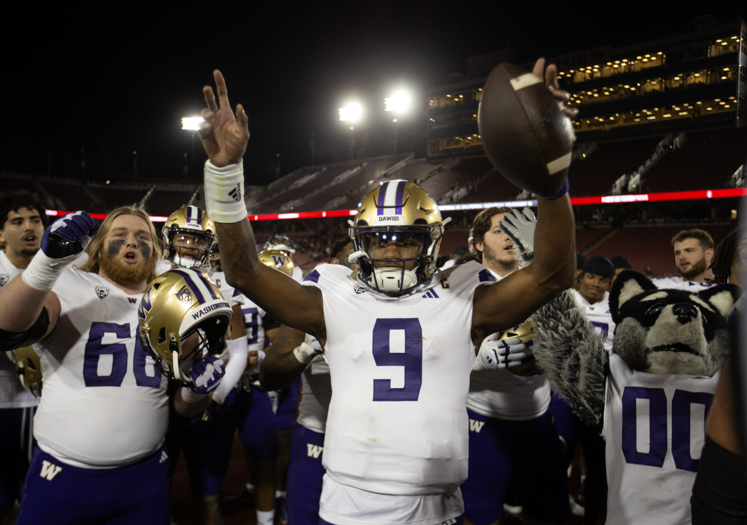 Washington Huskies quarterback Michael Penix Jr. (9) and his teammates celebrate their victory over the Stanford Cardinal.