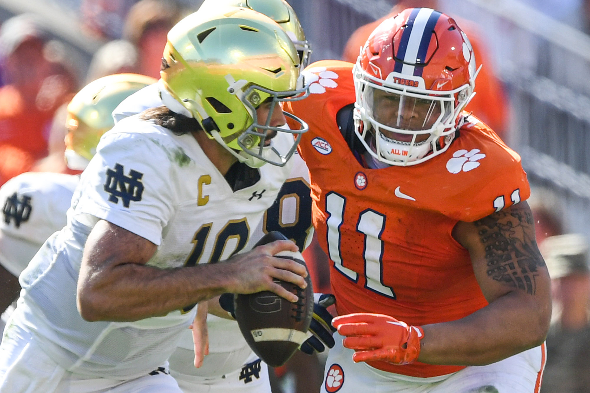 Nov 4, 2023; Clemson, South Carolina, USA; Notre Dame Fighting Irish quarterback Sam Hartman (10) runs against Clemson Tigers defensive lineman Peter Woods (11) for a touchdown during the third quarter at Memorial Stadium.