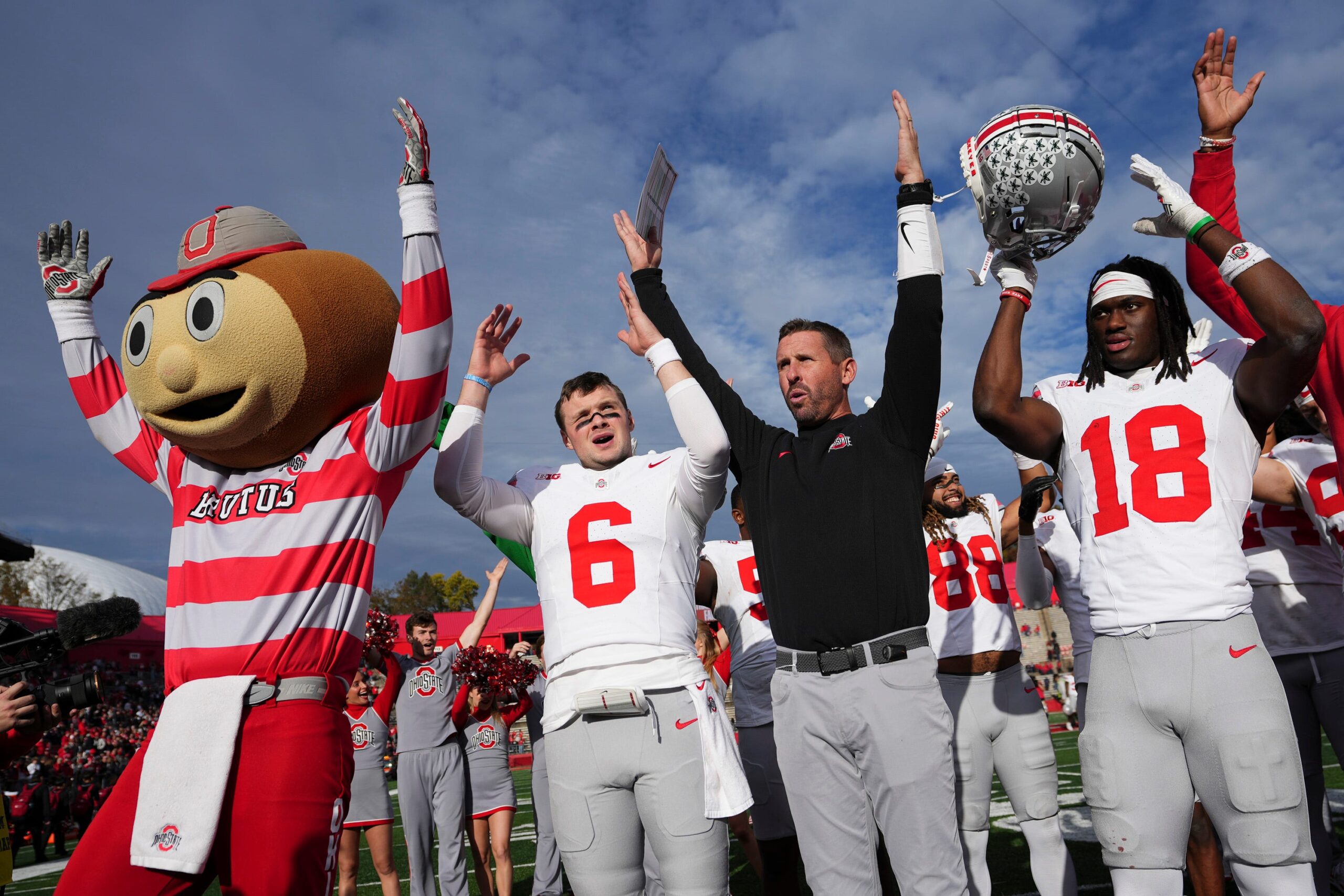Ohio State Buckeyes quarterback Kyle McCord (6), offensive coordinator Brian Hartline, and wide receiver Marvin Harrison Jr. (18) sing Carmen Ohio.