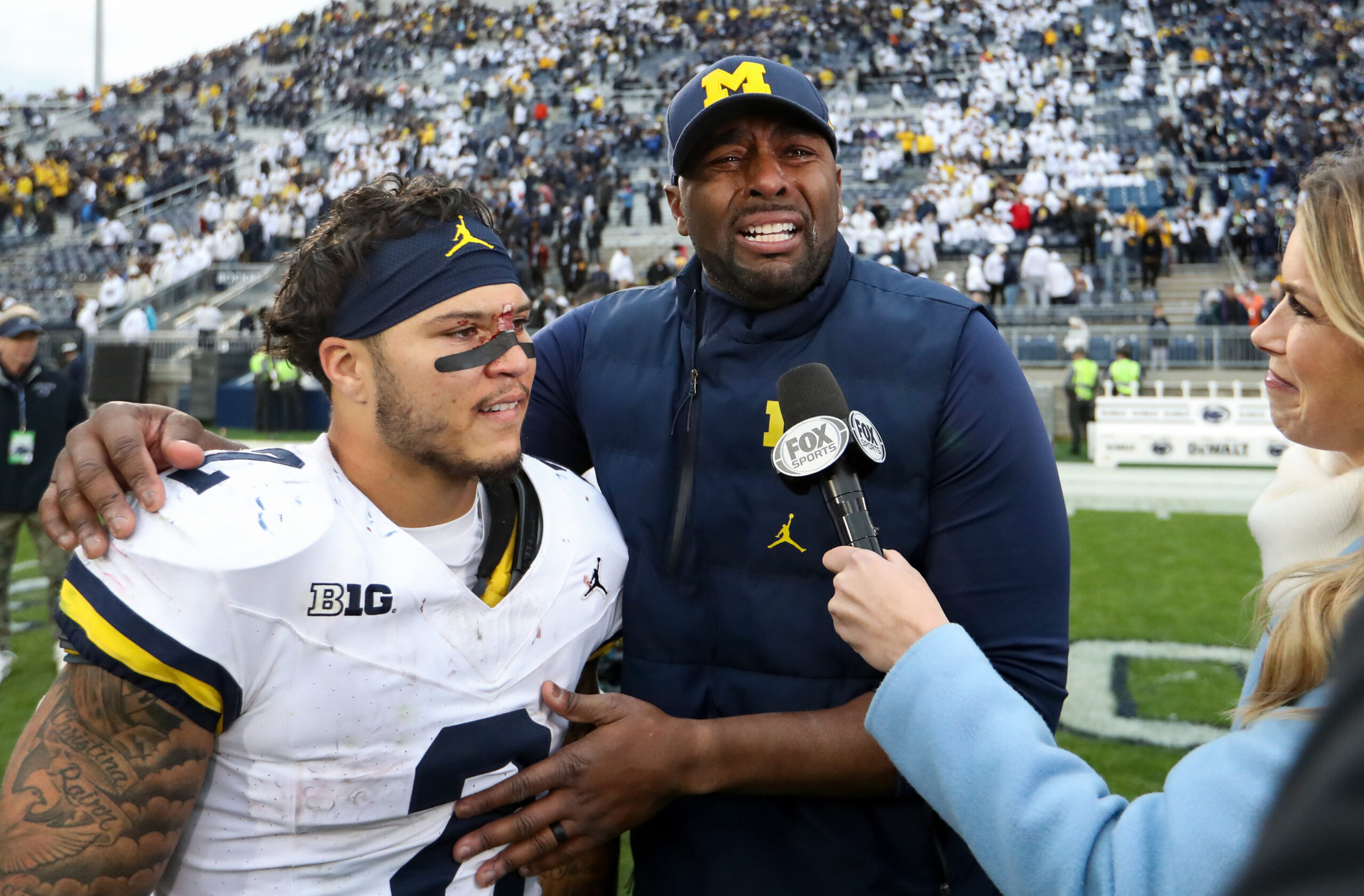 Nov 11, 2023; University Park, Pennsylvania, USA; Michigan Wolverines offensive line coach Sherrone Moore reacts while being interviewed with running back Blake Corum (2) following a game against the Penn State Nittany Lions at Beaver Stadium. Michigan won 24-15.