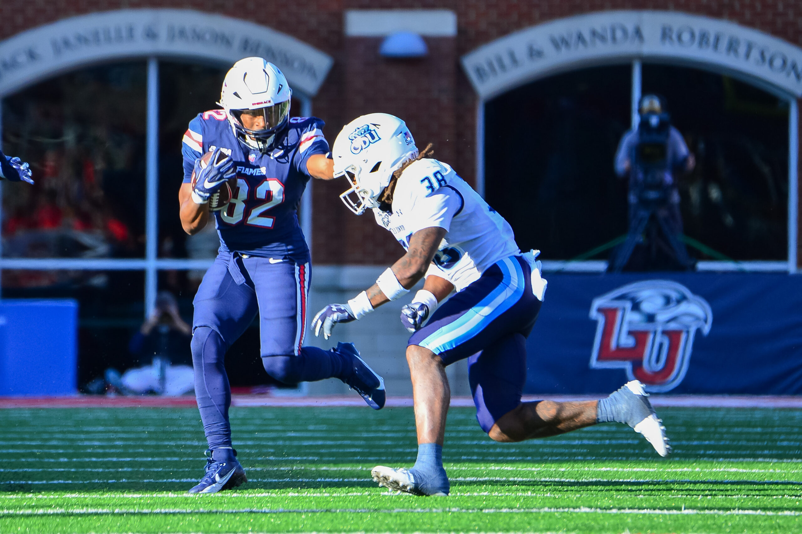 Nov 11, 2023; Lynchburg, Virginia, USA; Liberty Flames wide receiver Aaron Bedgood (82) runs after a catch while being pursued by Old Dominion Monarchs safety Ashton Whitner (38) at Williams Stadium. Mandatory Credit: Brian Bishop-USA TODAY Sports