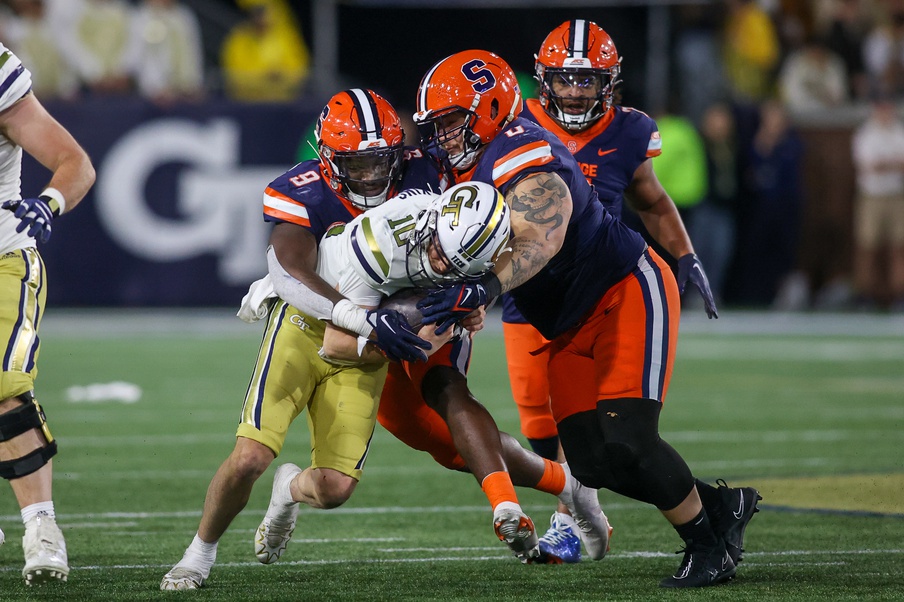 Nov 18, 2023; Atlanta, Georgia, USA; Georgia Tech Yellow Jackets quarterback Haynes King (10) is tackled by Syracuse Orange linebacker Leon Lowery (9) and defensive lineman Kevon Darton (0) in the second half at Bobby Dodd Stadium at Hyundai Field