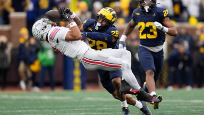 Michigan Wolverines defensive back Quinten Johnson (28) hits Ohio State Buckeyes wide receiver Emeka Egbuka (2)