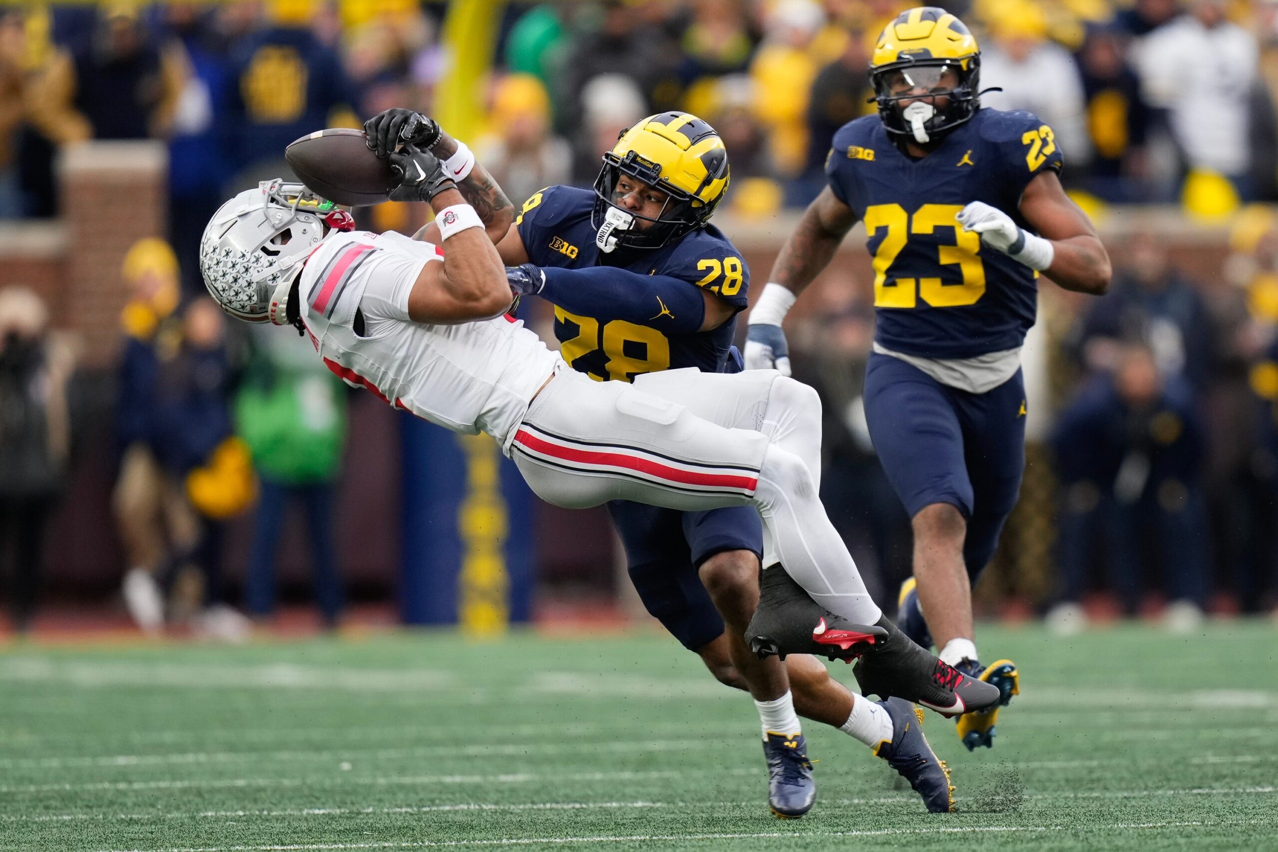 Michigan Wolverines defensive back Quinten Johnson (28) hits Ohio State Buckeyes wide receiver Emeka Egbuka (2), forcing an incomplete pass.