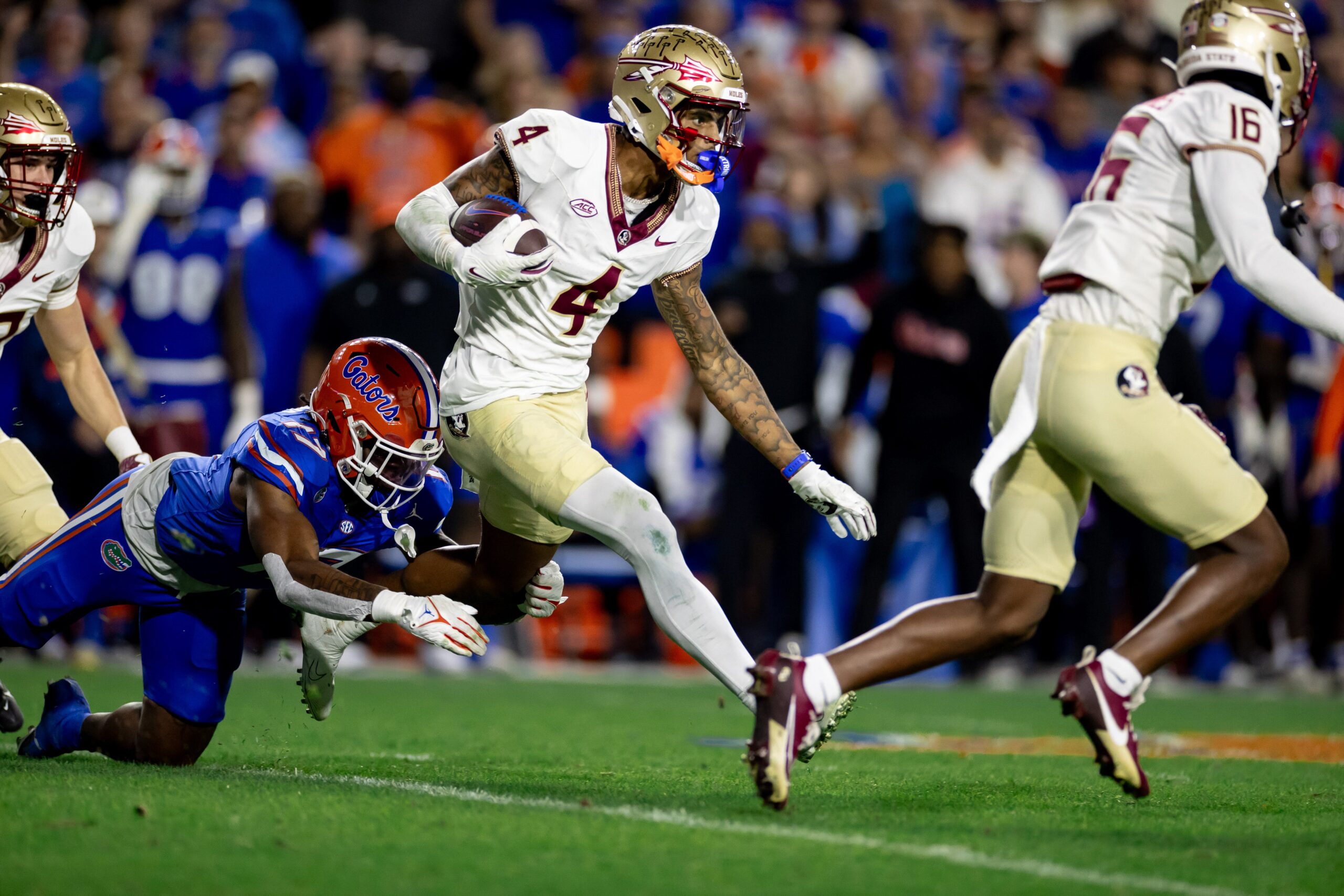 Florida State Seminoles wide receiver Keon Coleman (4) rushes with the ball for a touchdown breaking the tackle from Florida Gators linebacker Scooby Williams (17) during the second half at Steve Spurrier Field at Ben Hill Griffin Stadium in Gainesville, FL on Saturday, November 25, 2023.