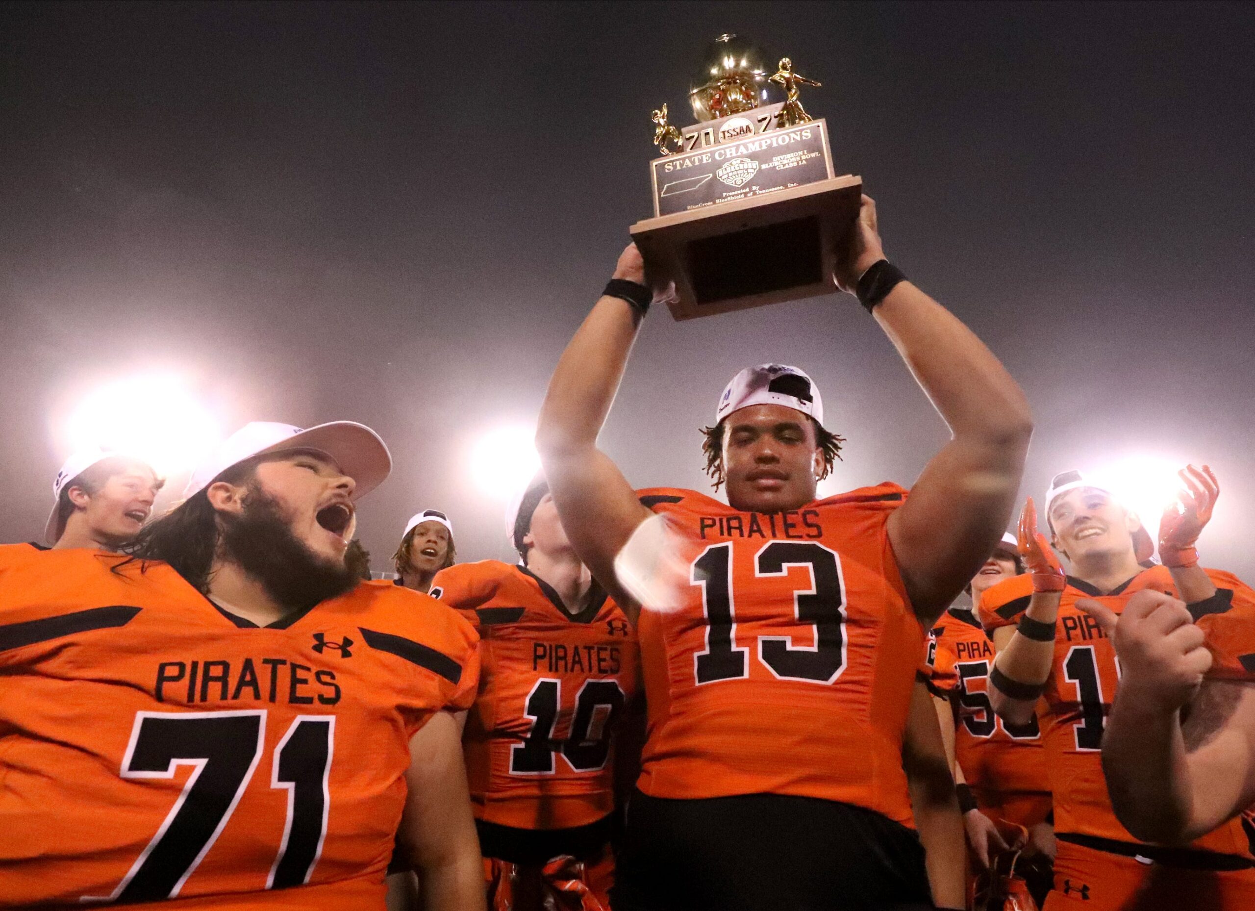 South Pittsburg's tight end Martavious Collins (13) holds up the TSSAA BlueCross Bowl Division I Class 1A Championship trophy as South Pittsburg's offensive lineman Omar Slatton (71) cheers after they beat McKenzie 14-7 at Finley Stadium in Chattanooga, Tenn. on Friday, Dec. 1, 2023.