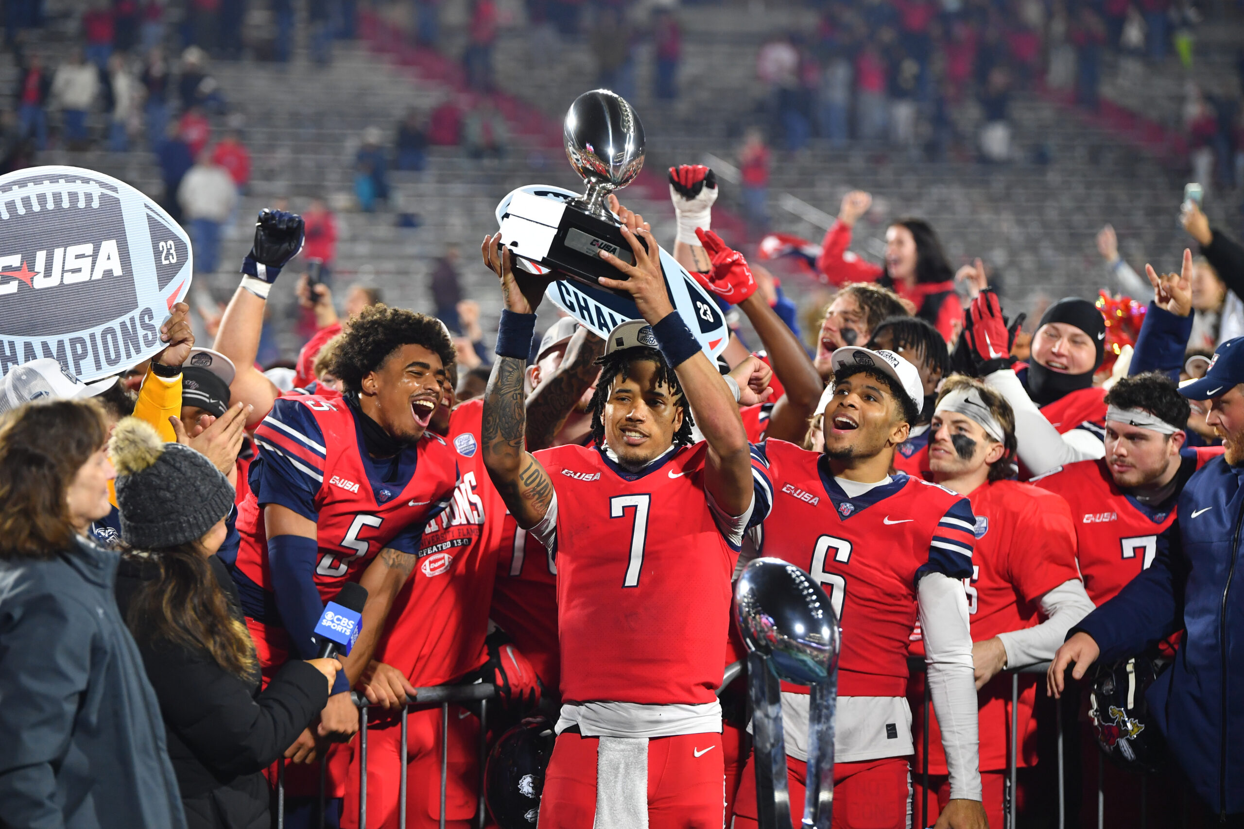 Dec 1, 2023; Lynchburg, VA, USA; Liberty Flames quarterback Kaidon Salter (7) holds up the Conference USA MVP trophy after the game against the New Mexico State Aggies at Williams Stadium.
