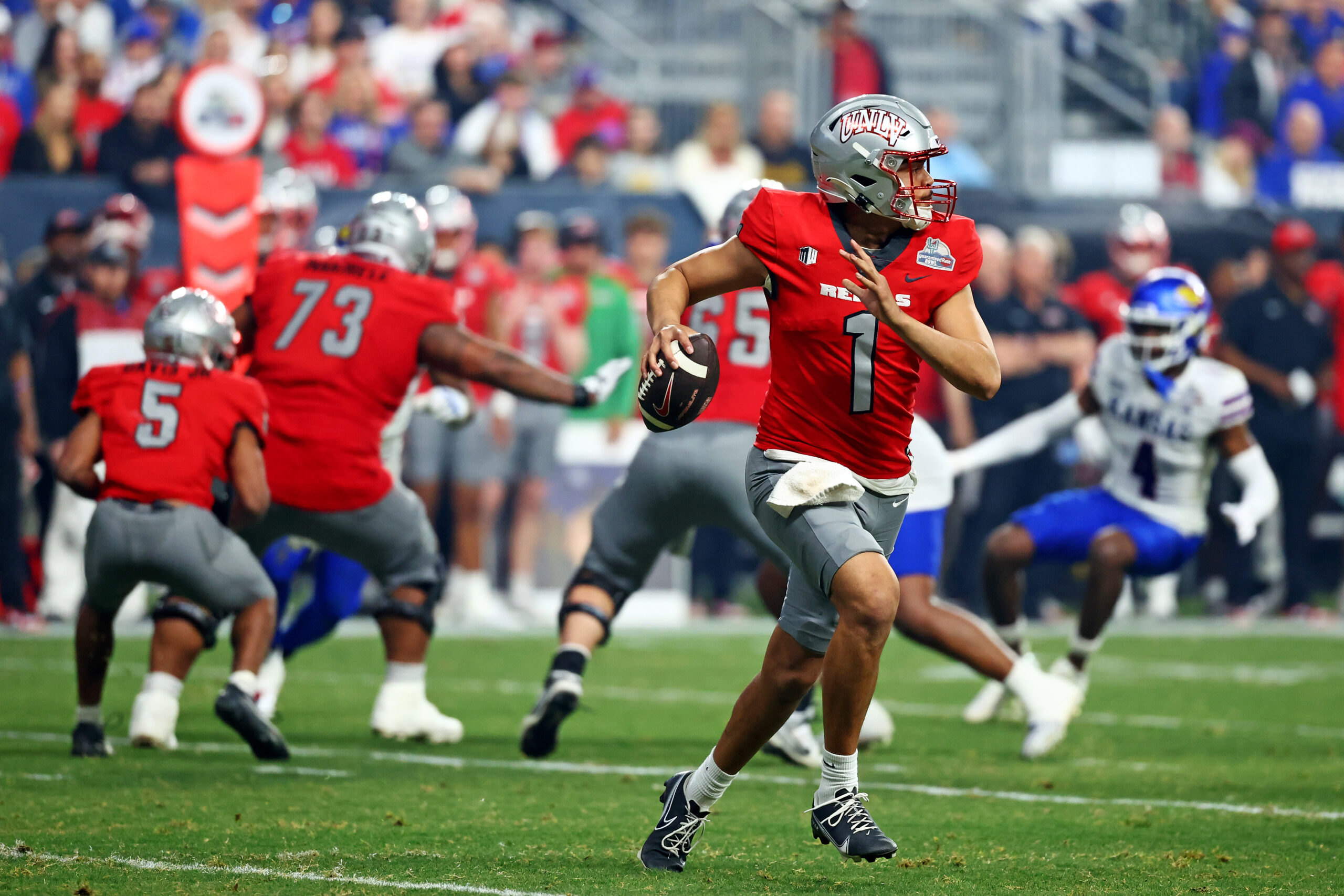Dec 26, 2023; Phoenix, AZ, USA; UNLV Rebels quarterback Jayden Maiava (1) rolls out to pass during the second half against the Kansas Jayhawks in the Guaranteed Rate Bowl at Chase Field. 