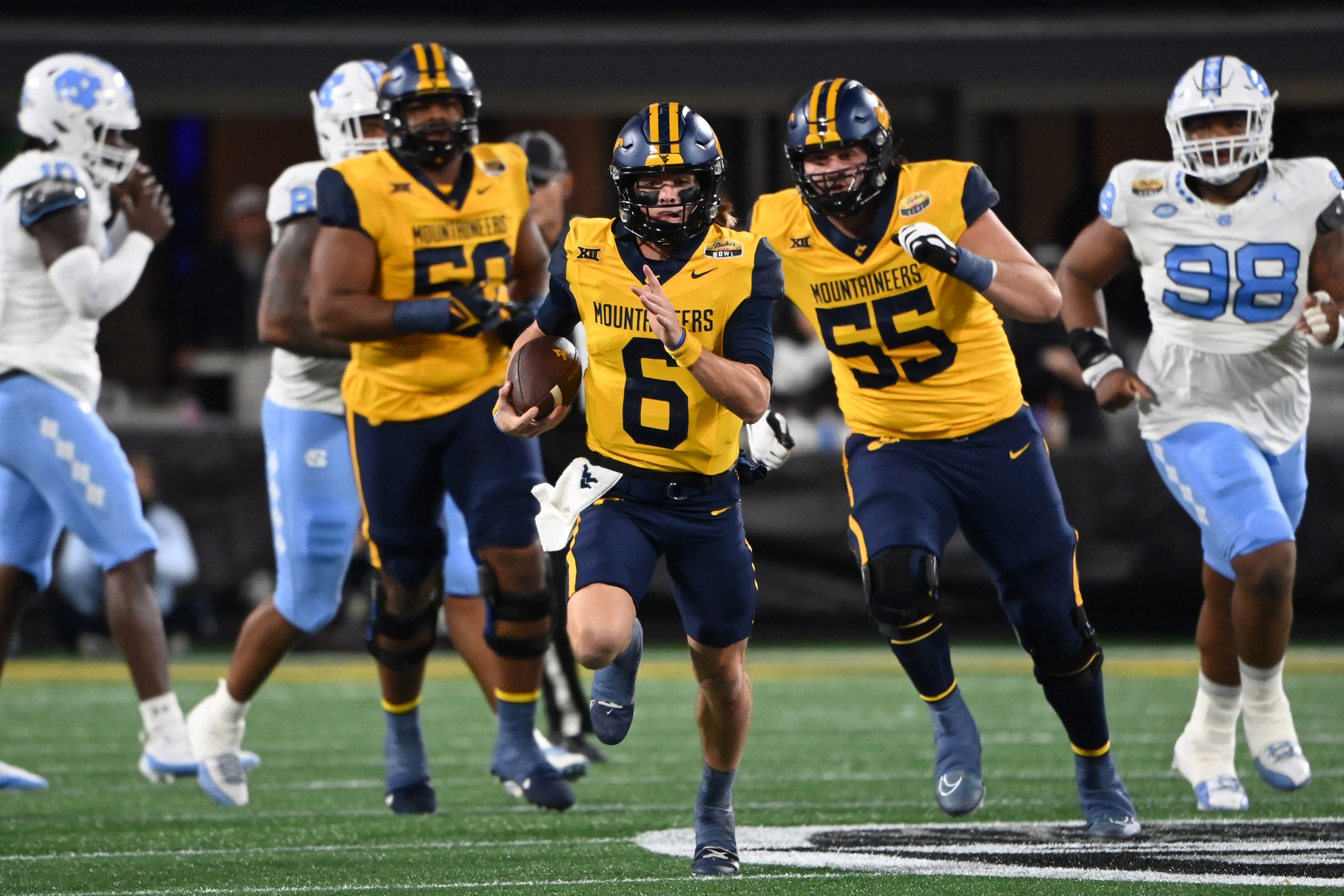 Dec 27, 2023; Charlotte, NC, USA; West Virginia Mountaineers quarterback Garrett Greene (6) runs in the first quarter at Bank of America Stadium.