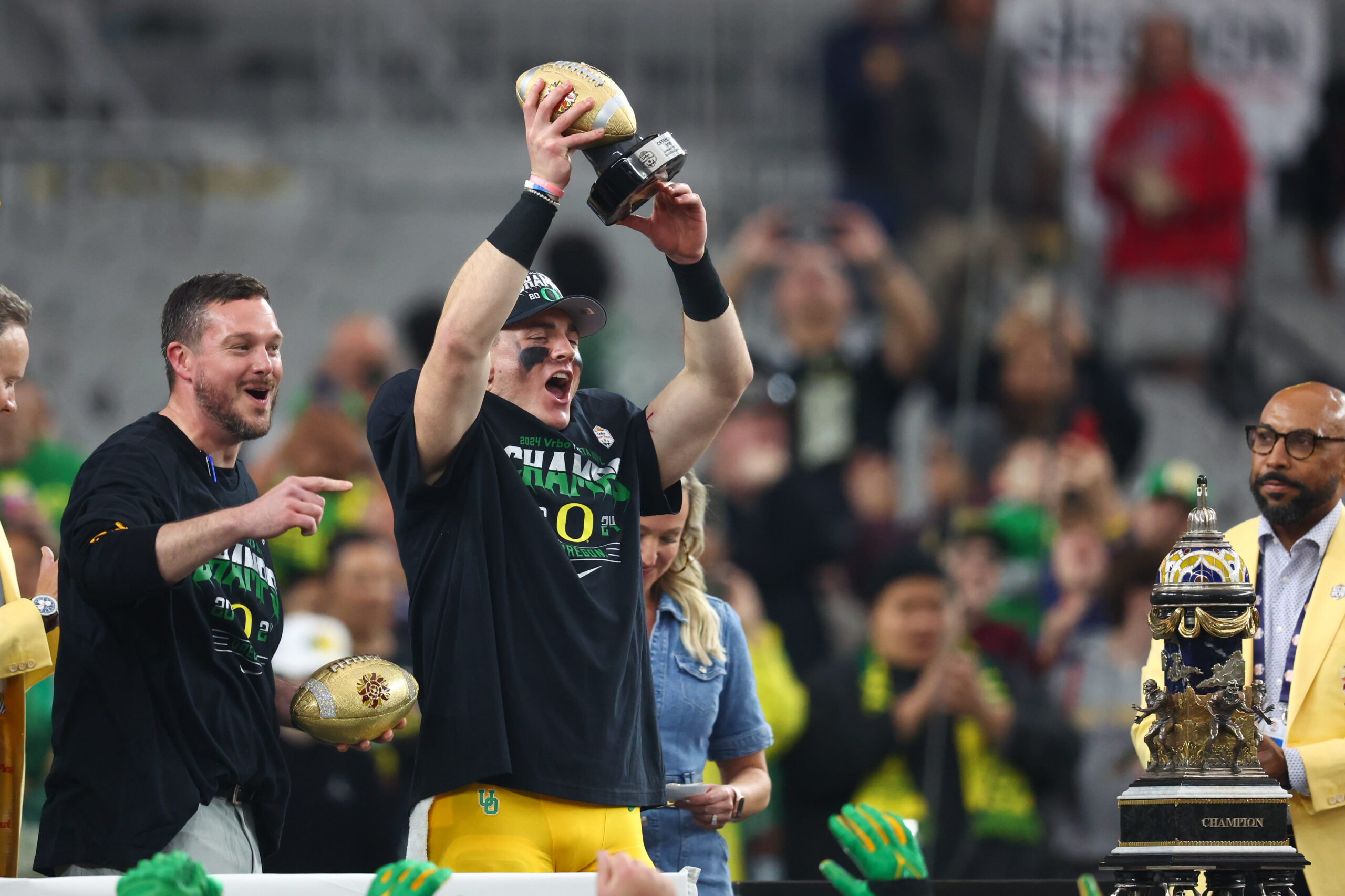 Jan 1, 2024; Glendale, AZ, USA; Oregon Ducks quarterback Bo Nix (10) lifts up the offensive MVP trophy after a victory against the Liberty Flames in the 2024 Fiesta Bowl at State Farm Stadium. The Ducks won 45-6.