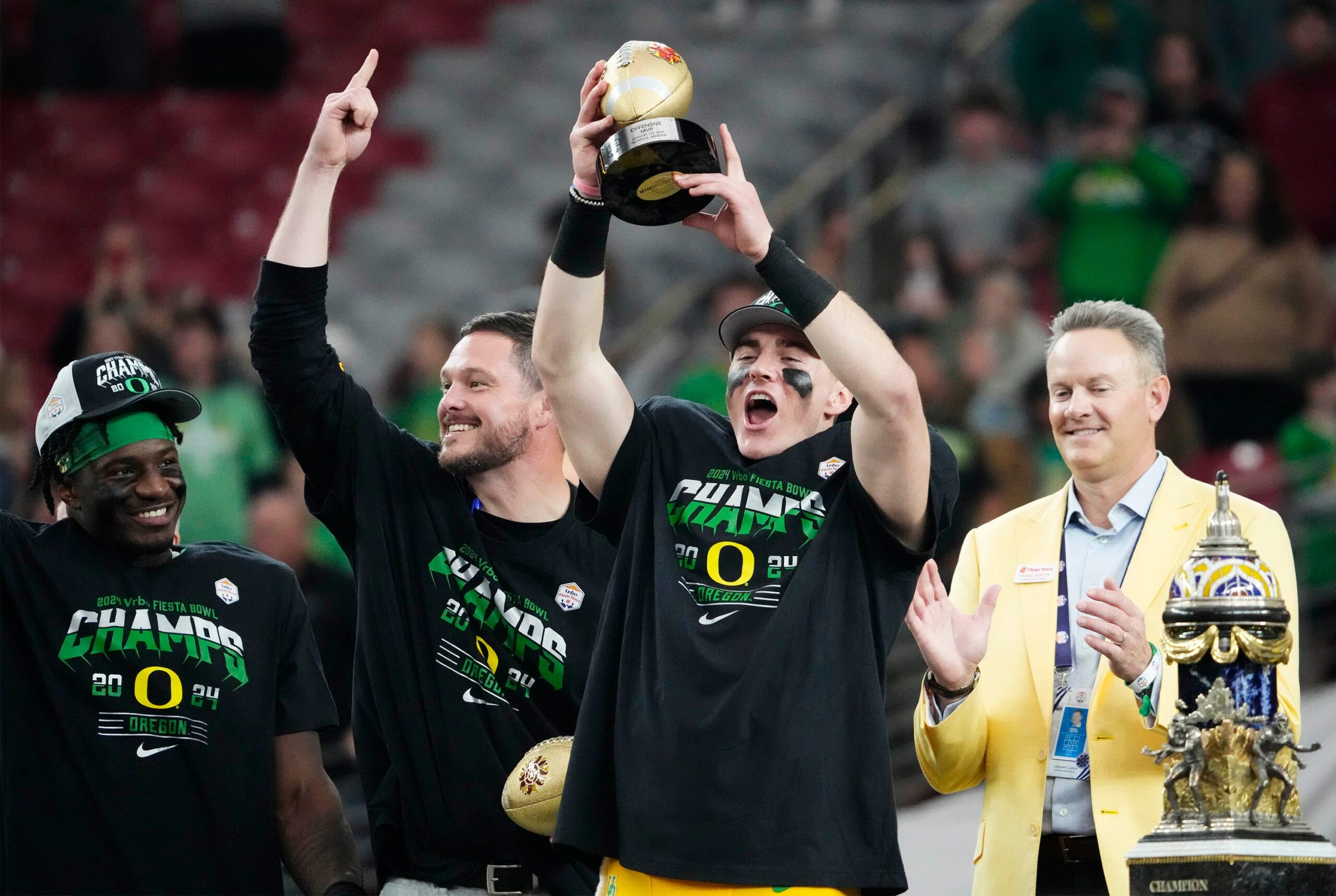 Jan 1, 2024; Glendale, AZ, USA; Oregon Ducks quarterback Bo Nix and head coach Dan Lanning celebrate after defeating the Liberty Flames to win the Fiesta Bowl at State Farm Stadium.