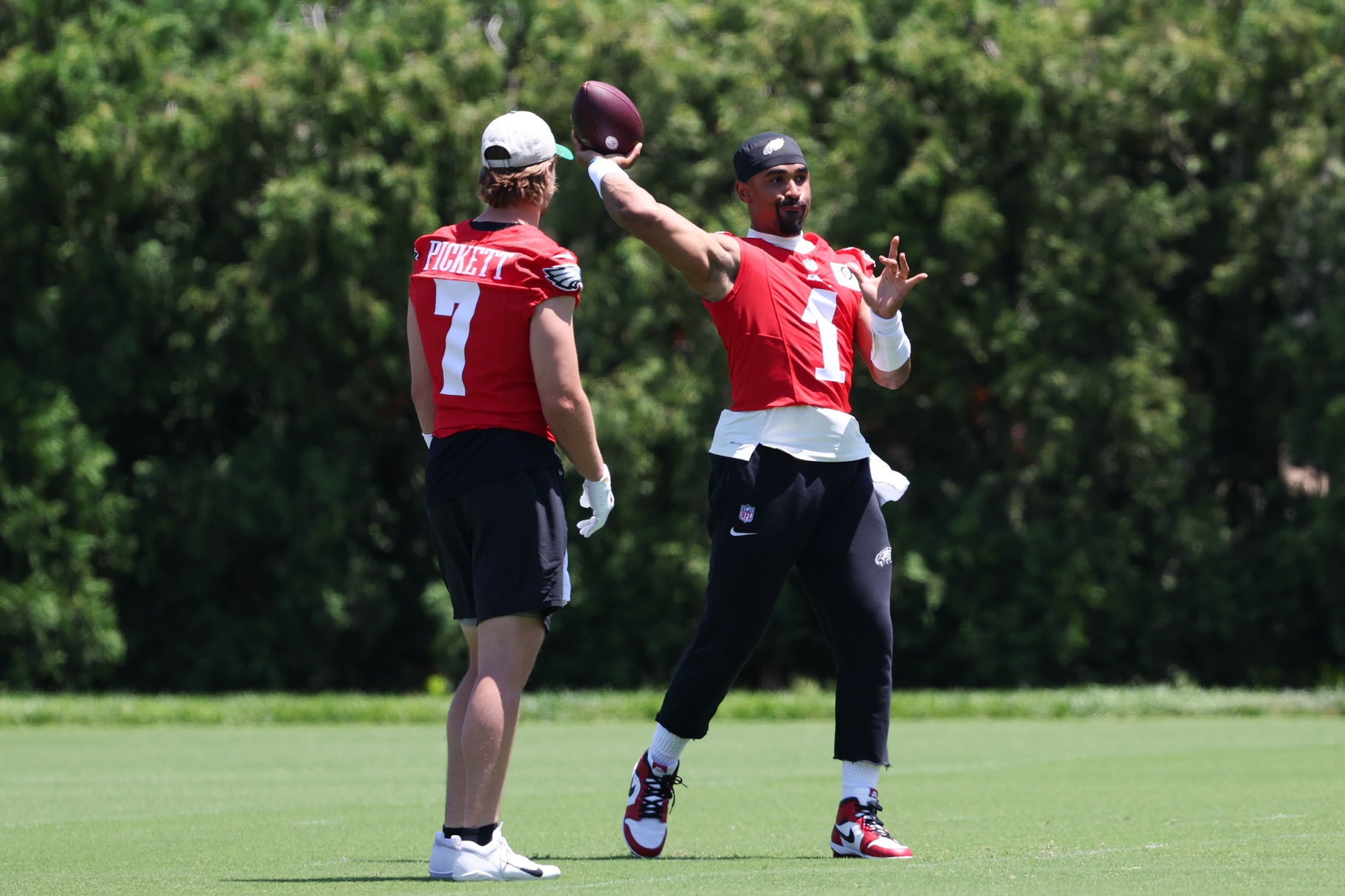 May 30, 2024; Philadelphia, PA, USA; Philadelphia Eagles quarterback Jalen Hurts (1) throws the ball in front of quarterback Kenny Pickett (7) at NovaCare Complex.