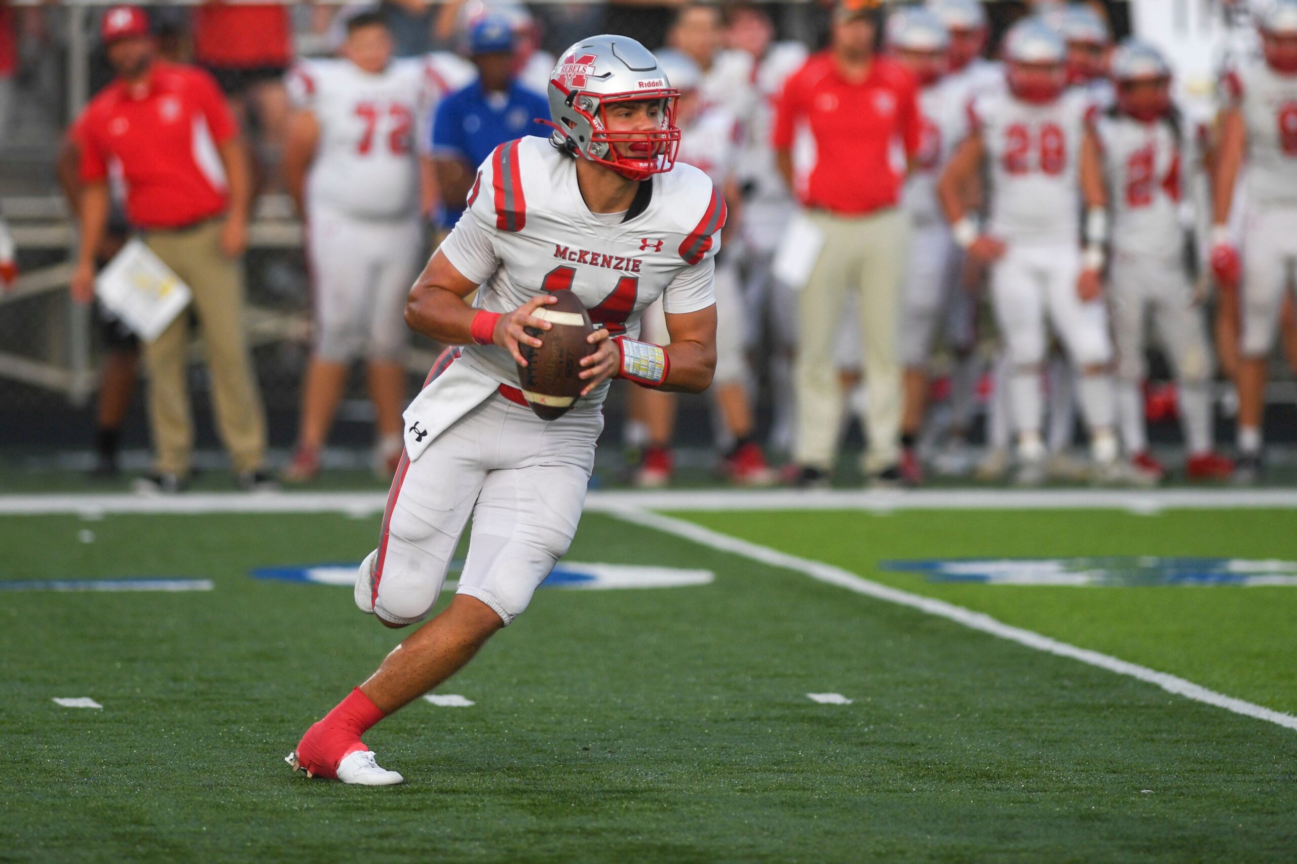 McKenzie's Tate Surber (14) surveys downfield for a receiver during the McKenzie vs Huntingdon TSSAA Football Season Opener in Huntingdon, Tenn., on Friday, August. 23, 2024.