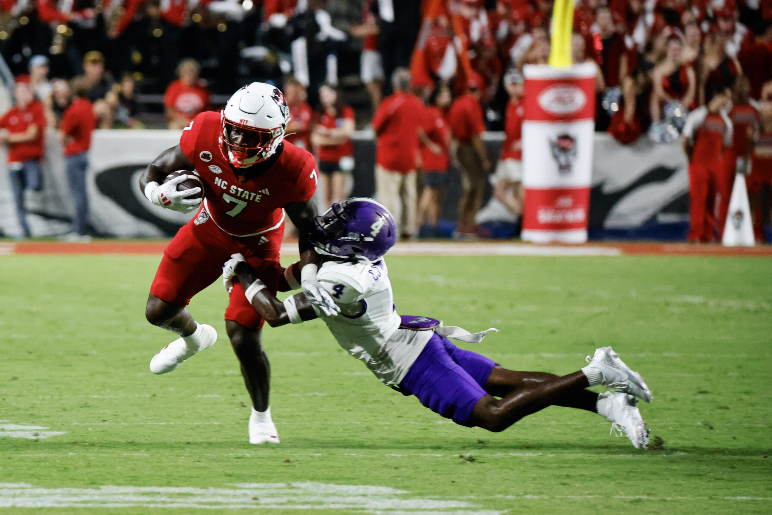 Aug 29, 2024; Raleigh, North Carolina, USA; Western Carolina Catamounts cornerback CJ Williams (4) tackles North Carolina State Wolfpack running back Jordan Waters (7) during the first half of the game against North Carolina State Wolfpack at Carter-Finley Stadium.
