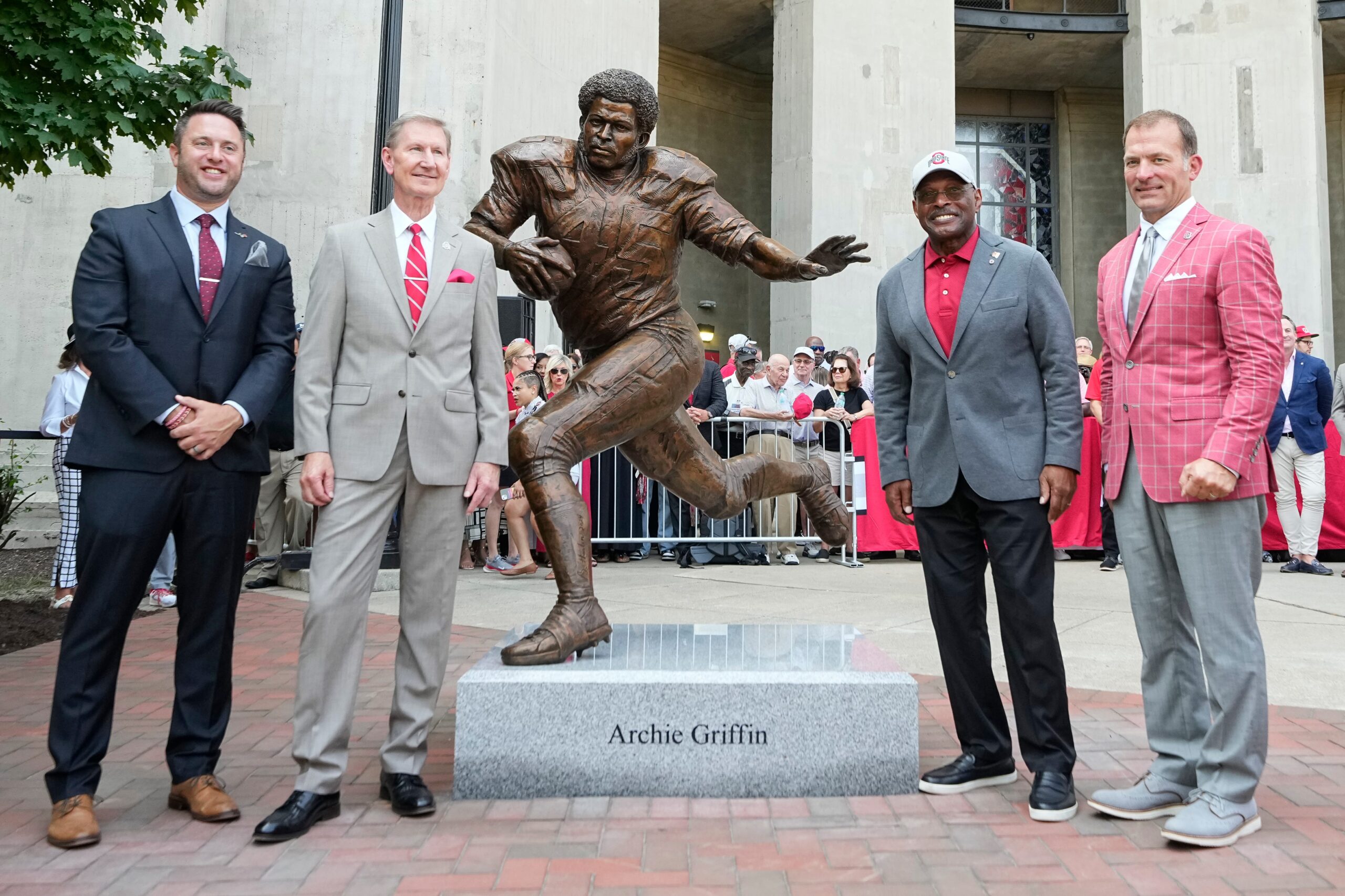 Aug 30, 2024; Columbus, OH, USA; From left, Rose Bowl Legacy Foundation President Dedan Brozino, Ohio State University President Ted Carter, former Buckeyes running back Archie Griffin and Senior VP and Wolfe Foundation-Eugene Smith Endowed Athletics Director Ross Bjork, stand with a statue for Griffin outside Ohio Stadium. The statue is a copy of the one that was created for the Rose Bowl by sculptor Brian Hanlon earlier this month.