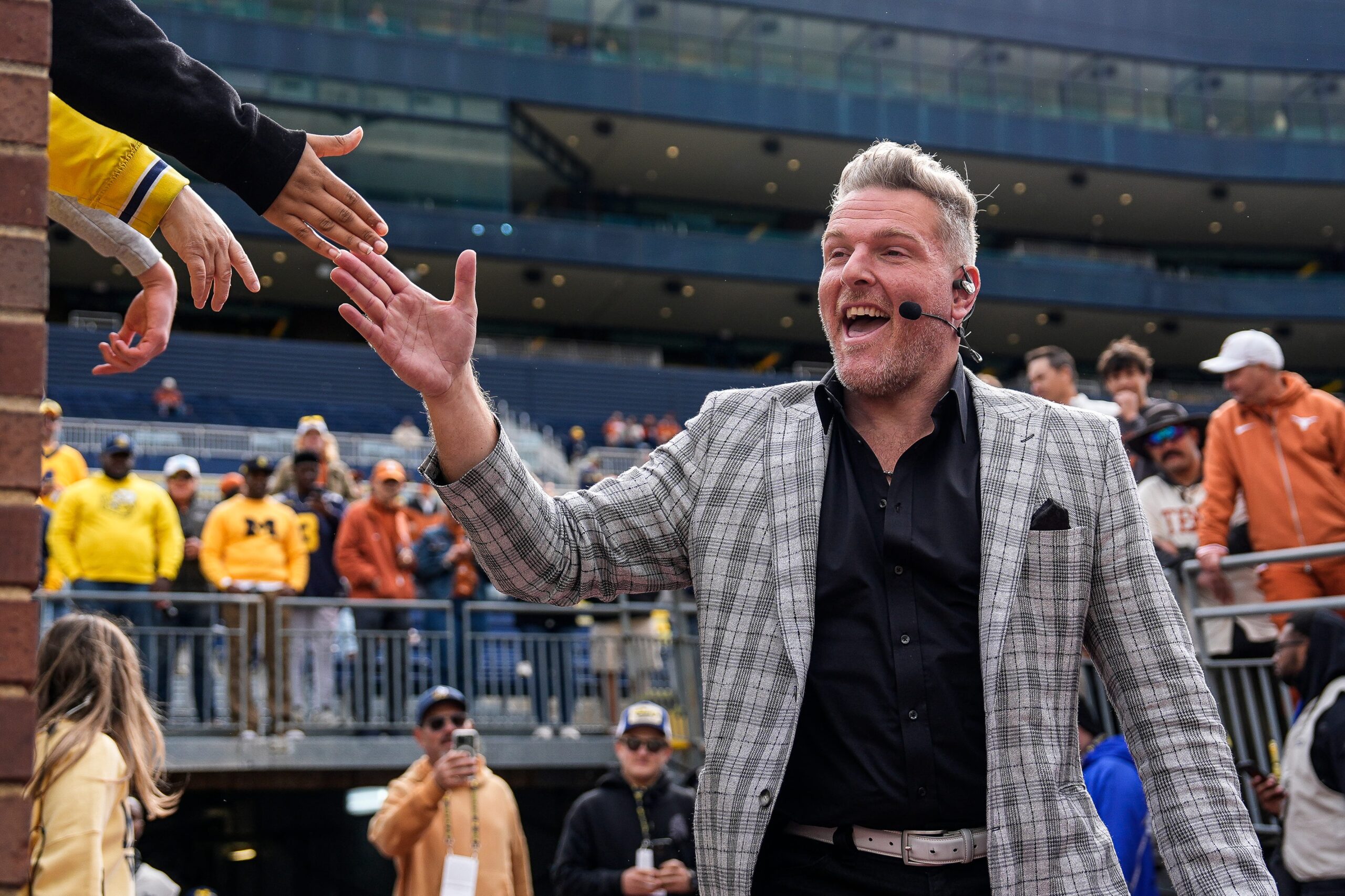ESPN College Game Day's Pat McAfee high-fives fans as he takes the field before the game between Michigan and Texas at Michigan Stadium in Ann Arbor on Saturday, September 7, 2024.