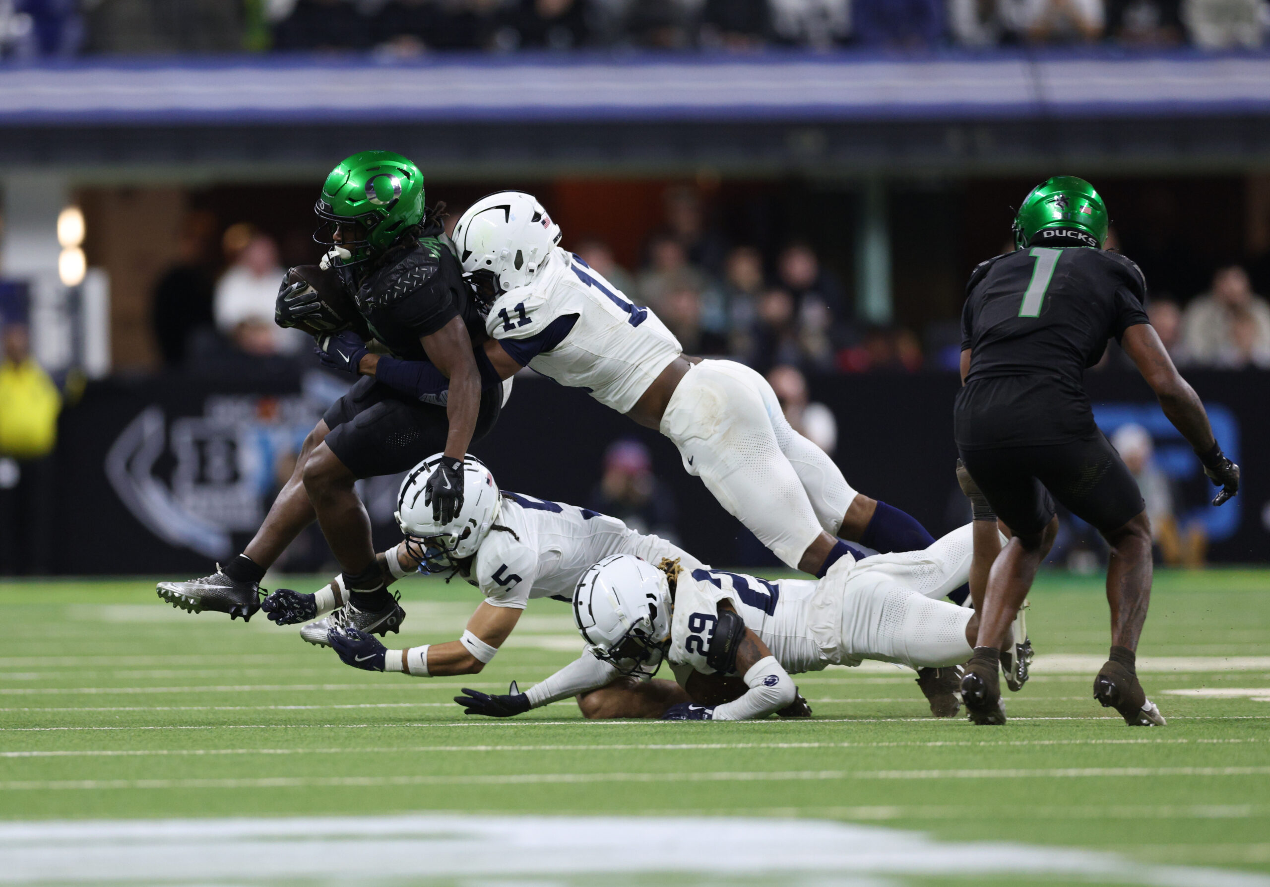 Dec 7, 2024; Indianapolis, IN, USA; Oregon Ducks running back Noah Whittington (6) is tackled by Penn State Nittany Lions defensive end Abdul Carter (11) during the fourth quarter in the 2024 Big Ten Championship game at Lucas Oil Stadium.