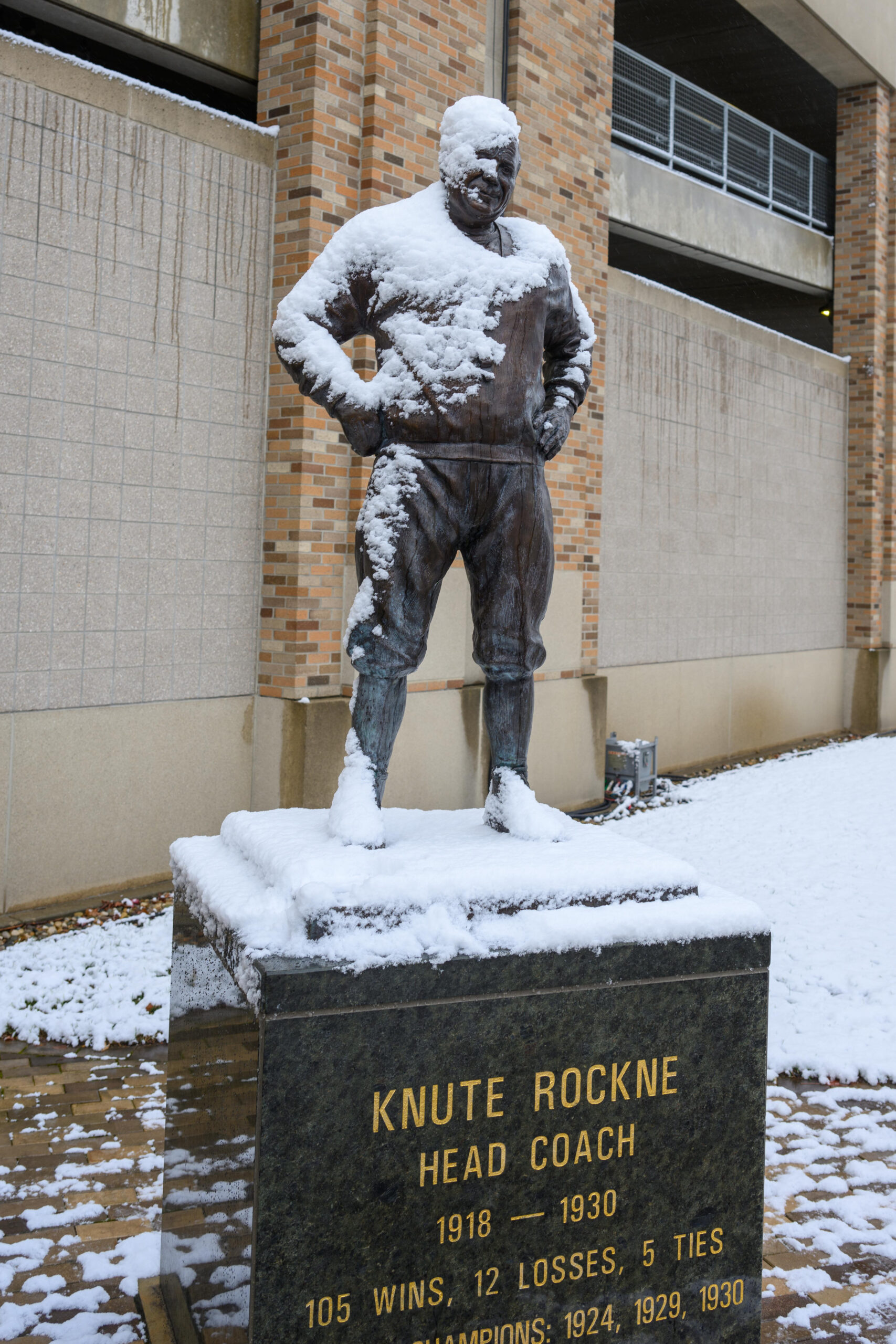 Dec 20, 2024; Notre Dame, Indiana, USA; A statue of Notre Dame Football coach Knute Rockne is covered in snow outside Notre Dame Stadium before a College Football Playoff first round game between the Notre Dame Fighting Irish and the Indiana Hoosiers at Notre Dame Stadium.