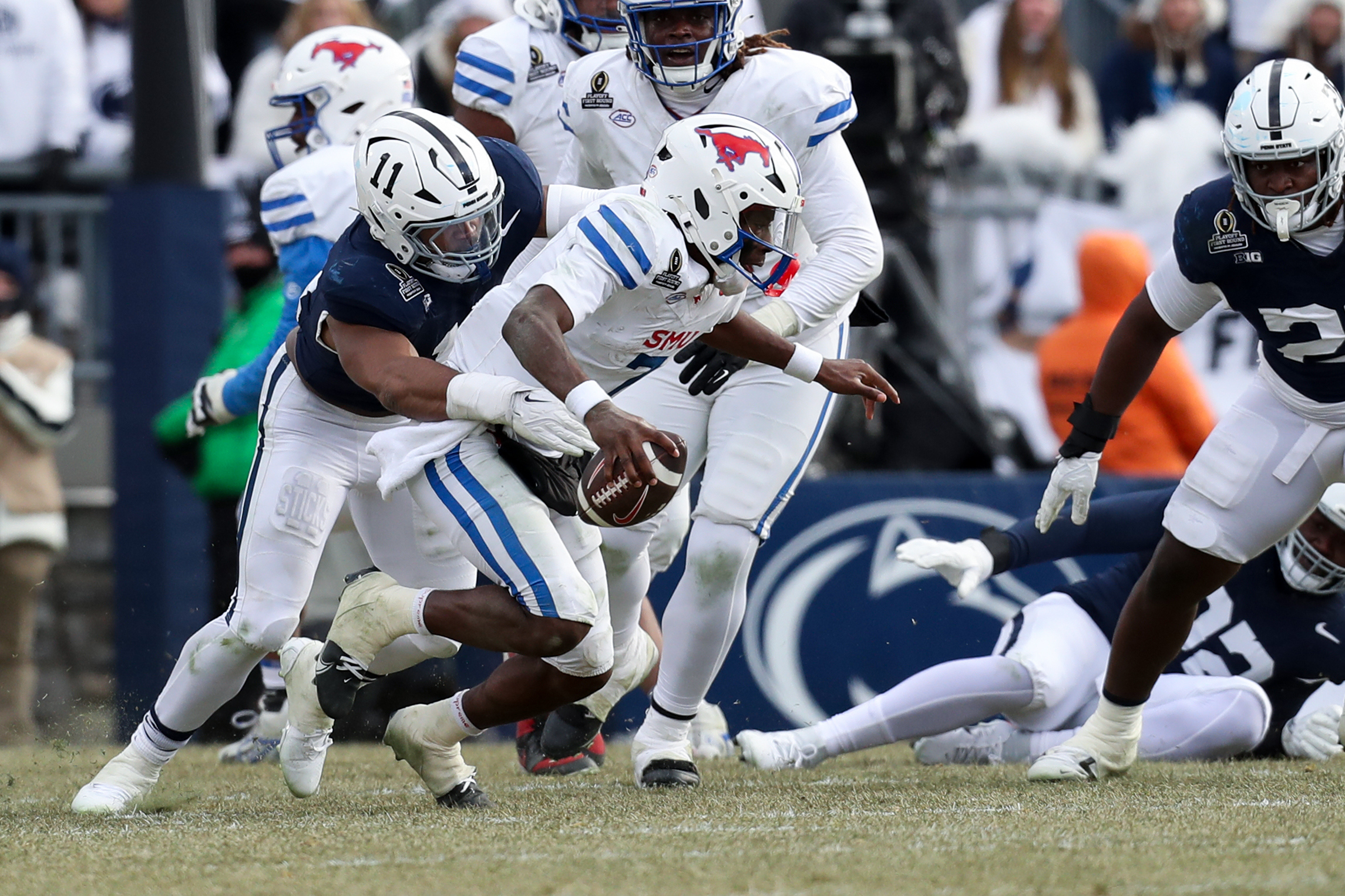Dec 21, 2024; University Park, Pennsylvania, USA; Southern Methodist Mustangs quarterback Kevin Jennings (7) is sacked by Penn State Nittany Lions defensive end Abdul Carter (11) during the third quarter in the first round of the College Football Playoff at Beaver Stadium.