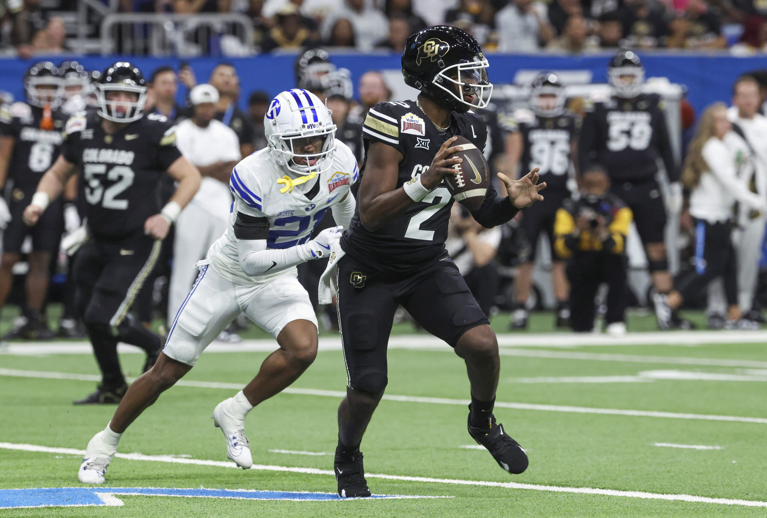 Dec 28, 2024; San Antonio, TX, USA; Colorado Buffaloes quarterback Shedeur Sanders (2) runs with the ball as Brigham Young Cougars cornerback Evan Johnson (21) attempts to make a tackle during the third quarter at Alamodome.