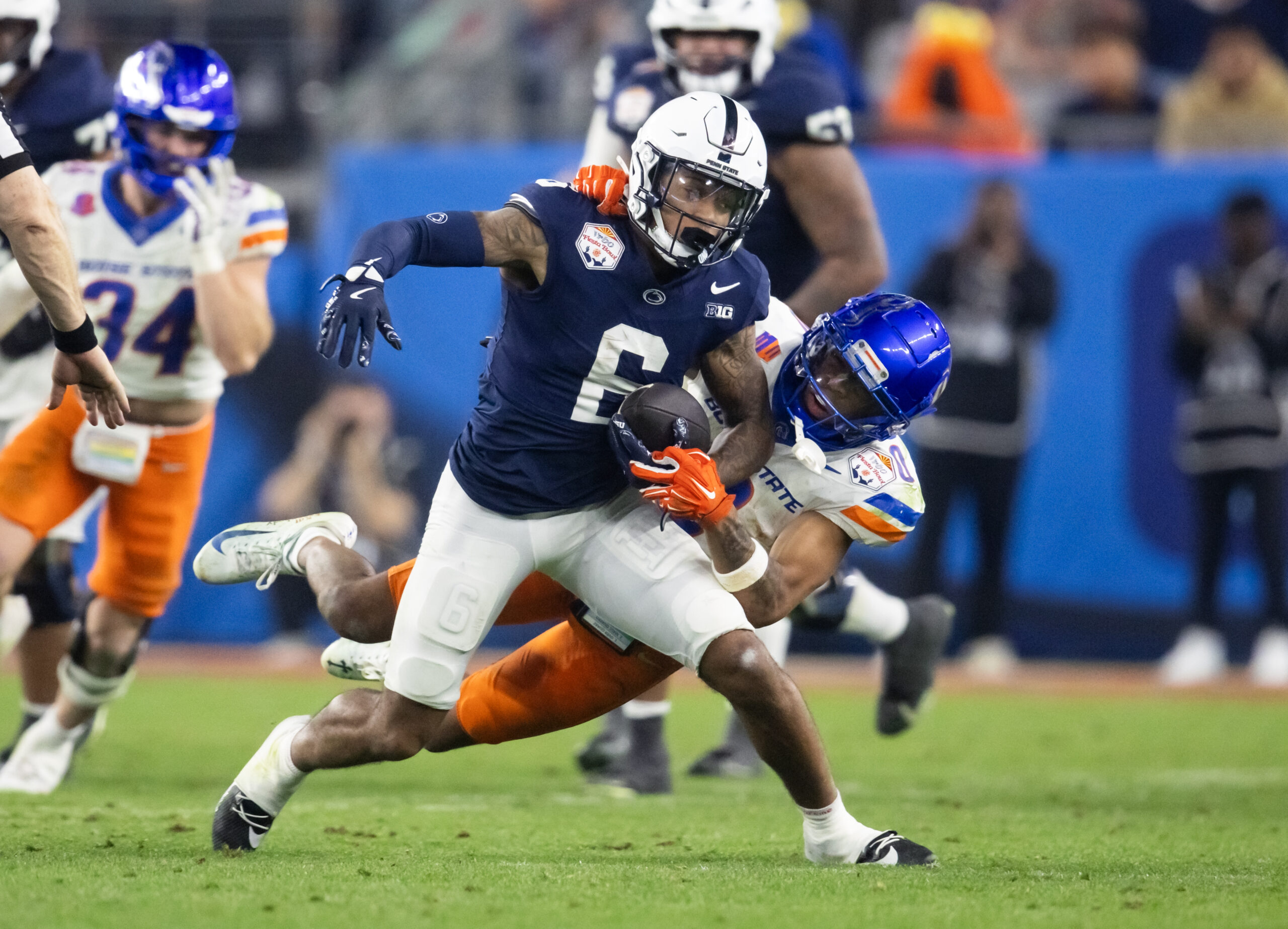 Dec 31, 2024; Glendale, AZ, USA; Penn State Nittany Lions wide receiver Harrison Wallace III (6) is tackled by Boise State Broncos safety Ty Benefield (0) during the Fiesta Bowl at State Farm Stadium.