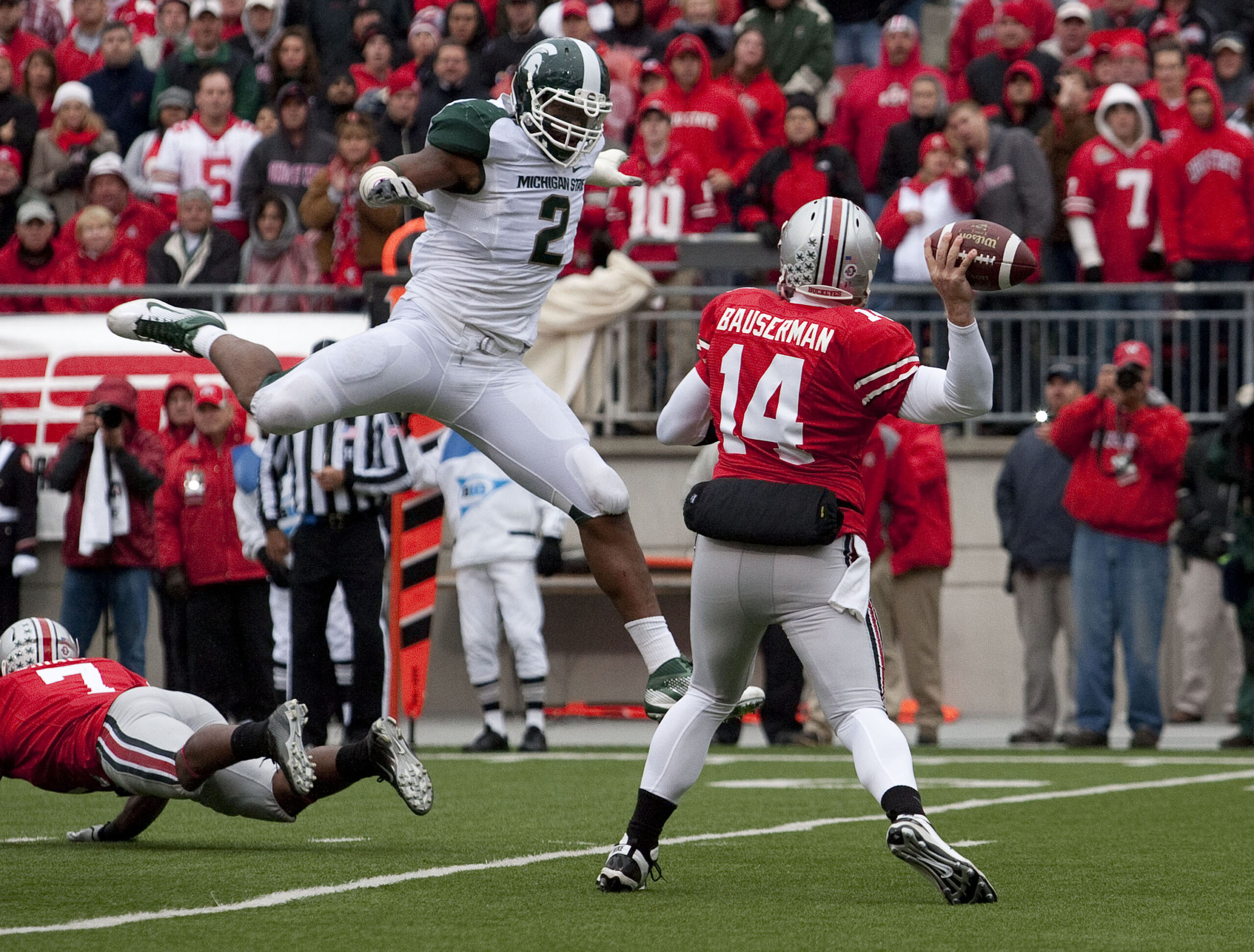 October 1, 2011; Columbus, OH, USA; Ohio State Buckeyes quarterback Joe Bauserman (14) tries to get a pass around Michigan State Spartans linebacker William Gholston (2) at Ohio Stadium. Michigan State won the game 10-7.