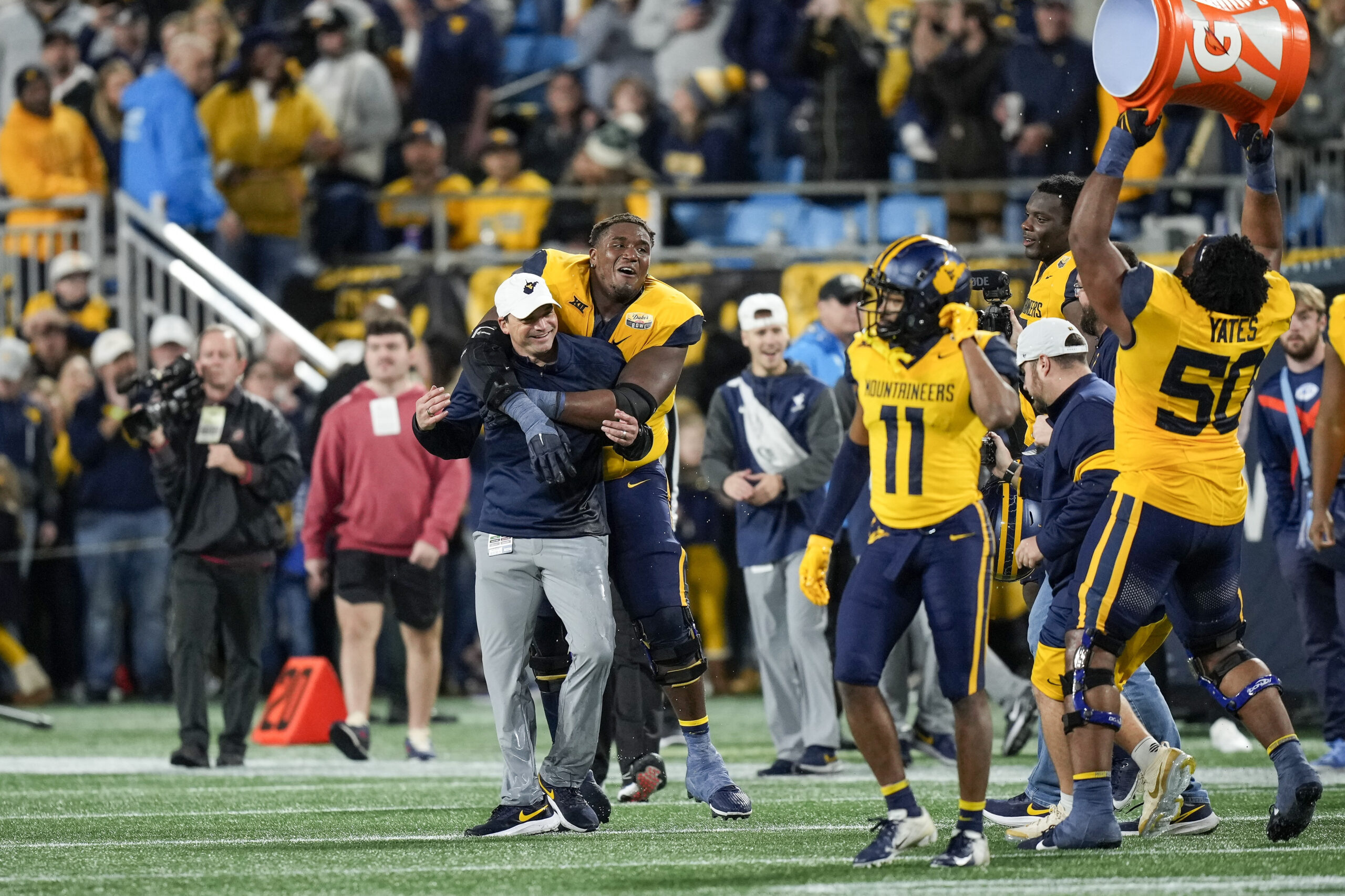 Dec 27, 2023; Charlotte, NC, USA; West Virginia Mountaineers head coach Neal Brown celebrates with his team after the win over North Carolina Tar Heels during the second half at Bank of America Stadium. 