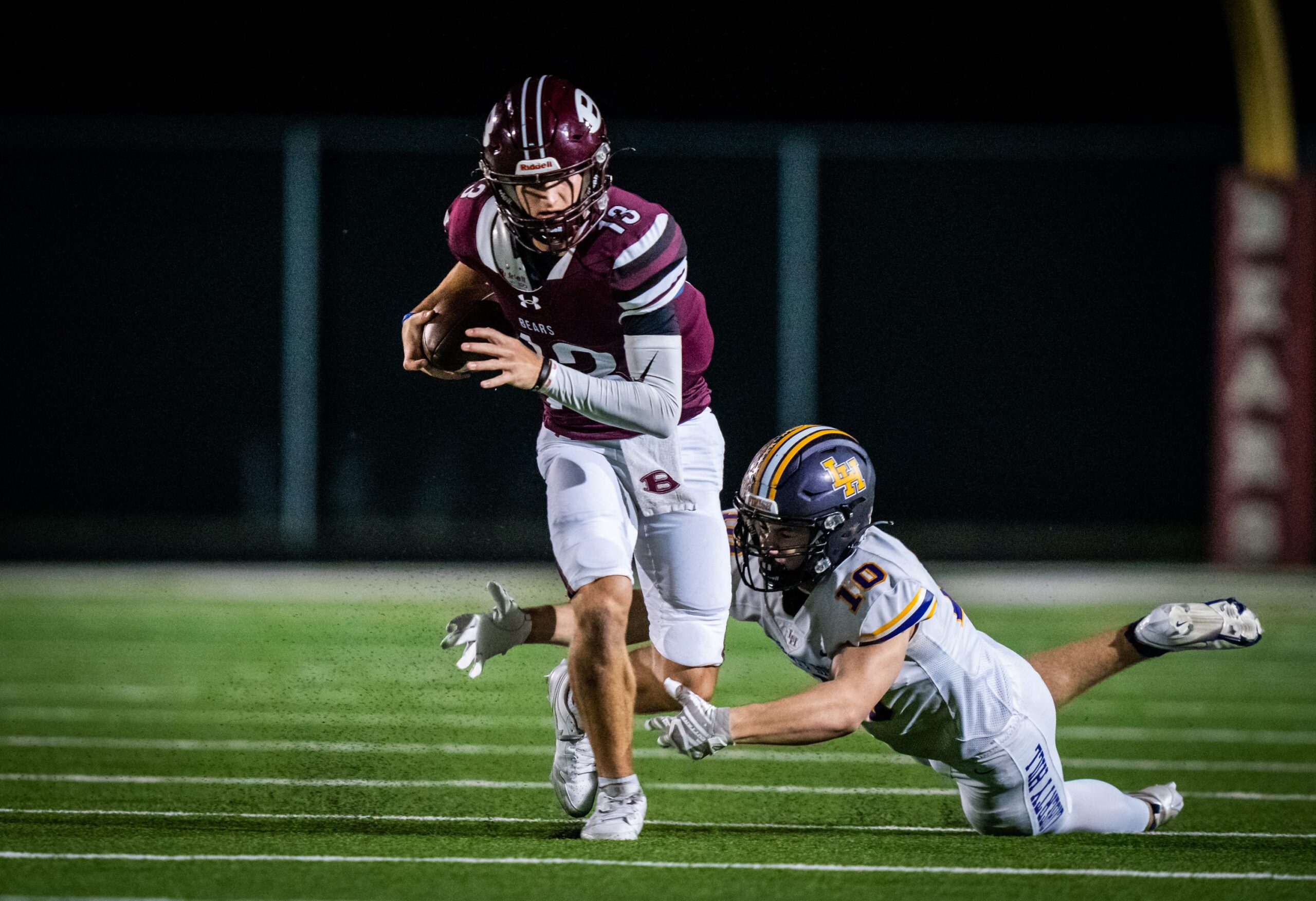 Bastrop quarterback Weston Nielson (13) carries the ball as Liberty Hill linebacker Garrett Lindgren (10) dives to tackle him in the first quarter of the game in Bastrop between the Bears and the Panthers, Nov. 8, 2024. Both teams go into the game undefeated in district play with the district championship on the line.