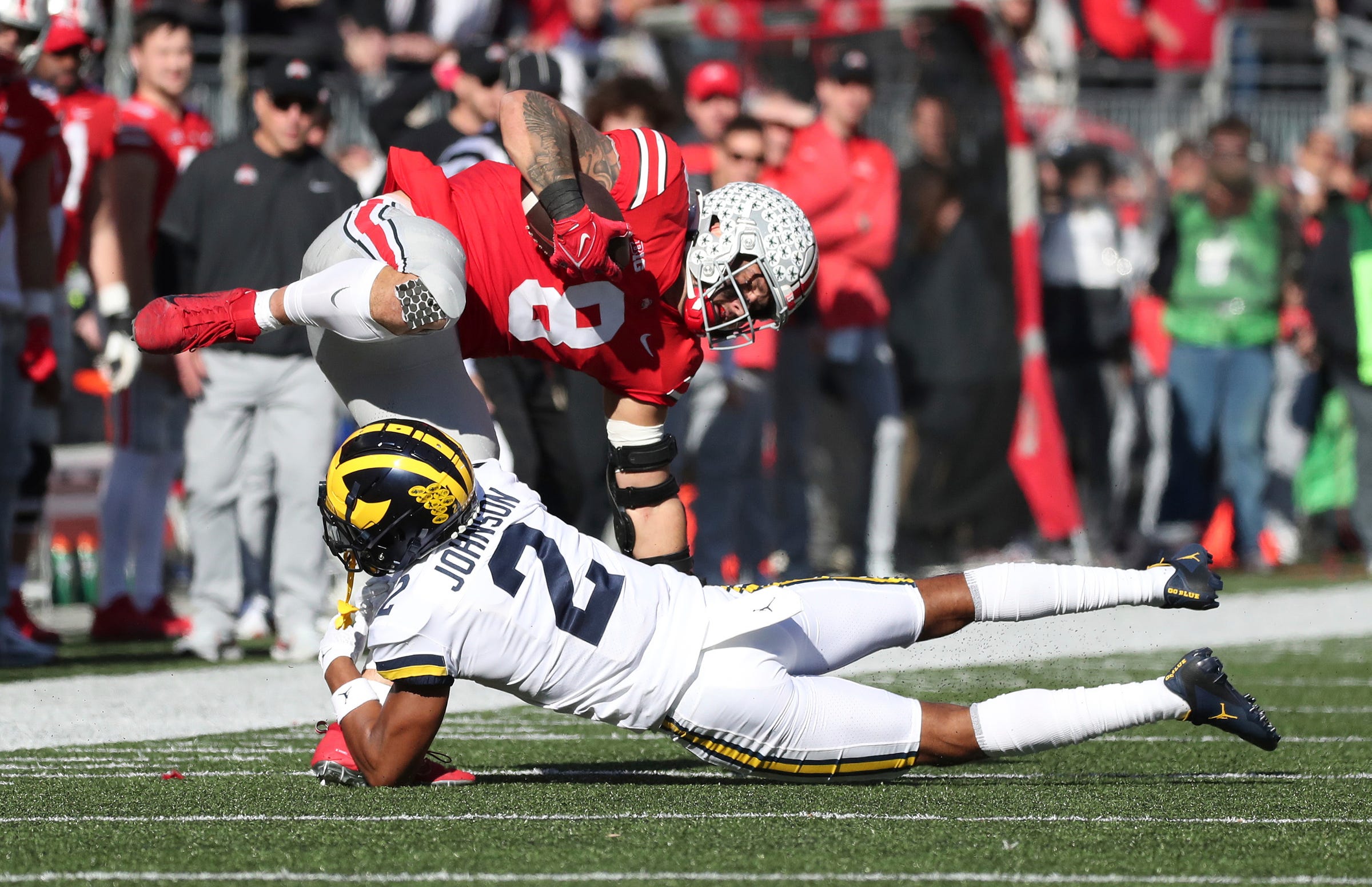 Michigan defensive back Will Johnson (2) tackles Ohio State tight end Cade Stover during the first half at Ohio Stadium in Columbus on Nov. 26, 2022.
