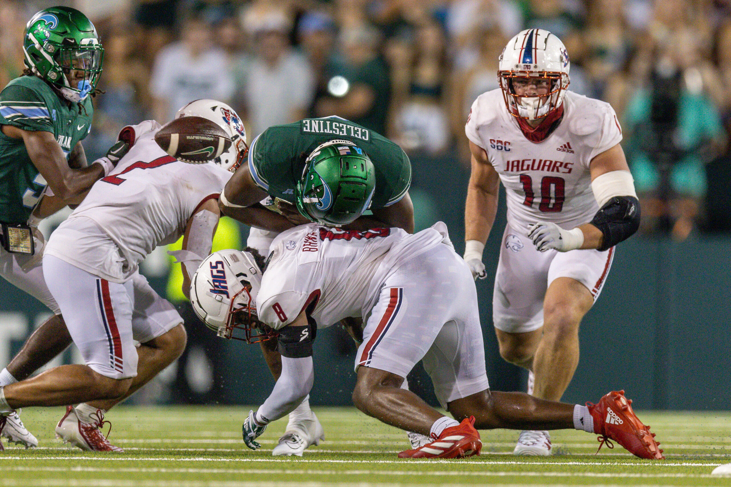Sep 2, 2023; New Orleans, Louisiana, USA; Tulane Green Wave running back Iverson Celestine (8) fumbles the ball on a hit by South Alabama Jaguars safety Yam Banks (8) during the second half at Yulman Stadium.