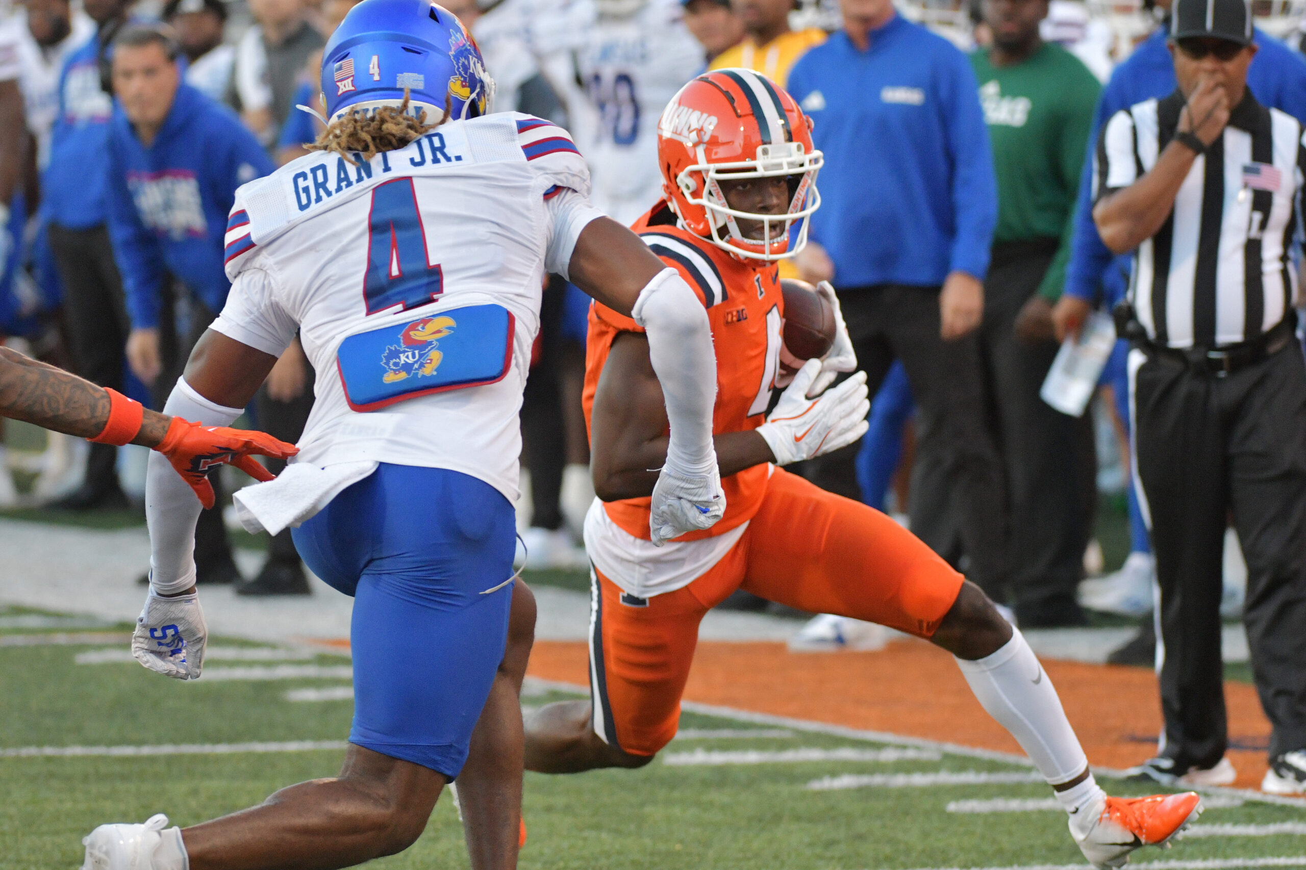 Caption: Sep 7, 2024; Champaign, Illinois, USA; Illinois Fighting Illini wide receiver Zakhari Franklin (4) runs for a first down as Kansas Jayhawks safety Marvin Grant (4) pursues during the first half at Memorial Stadium.