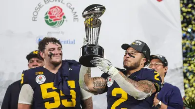 Rose Trophy: Michigan running back Blake Corum (2) lifts the trophy after a 27-20 win over Alabama.