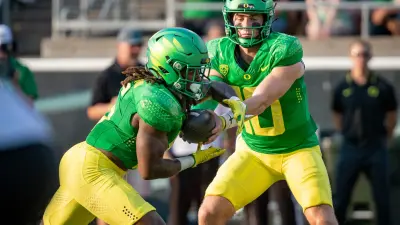 Oregon quarterback Bo Nix hands off the ball to running back Noah Whittington as the Oregon Ducks host Hawaii Saturday