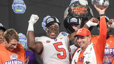 Clemson coach Dabo Swinney raises the ACC championship trophy with Tigers defensive end K.J. Henry (5) after Clemson's win against North Carolina in the ACC Championship Game at Bank of America Stadium in Charlotte