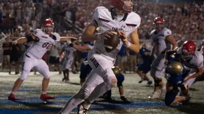 Brentwood Academy's George MacIntyre (12) has to scramble in his own end zone as Brentwood pressures him late in the fourth quarter at James C. Parker Stadium Friday night