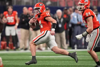 Dec 7, 2024; Atlanta, GA, USA; Georgia Bulldogs quarterback Gunner Stockton (14) rushes the ball against the Texas Longhorns during the second half in the 2024 SEC Championship game at Mercedes-Benz Stadium. 