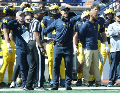 Connor Stalions, left, stands next to Michigan coach Jim Harbaugh during the team's game against Rutgers, Sept. 23, 2023, at Michigan Stadium in Ann Arbor.